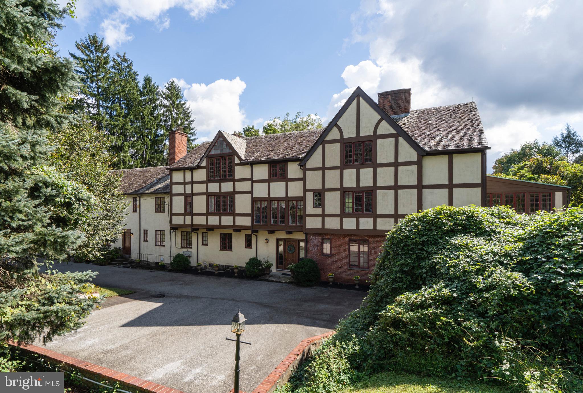 Impressive English manor home situated on desirable cul-de-sac in Villanova. This remarkable property sits on almost a full acre of green with a slate terrace and in-ground pool, creating an oasis for family use and entertaining. With over 7000 square feet of living space, this expansive Main Line gem features high ceilings, hardwood floors, and an in-law/au pair suite. The spacious living room enjoys an abundance of natural light from large windows overlooking the pool and terrace. The paneled library/office has a hidden bathroom, built in bookcases, and a fireplace.  A cozy den with powder room is found just off the eat-in kitchen. Step back in time as you enter the formal dining room complete with fireplace, chandelier, and French doors leading to the slate terrace, where you can relax with a view of the pool and enchanting green surroundings. The main staircase guides you to the master bedroom which boasts a fireplace and sleeping porch. The second and third floors offer 5 additional bedrooms, 4 baths, and 2 bonus rooms. The second floor hallway invites you into a 3 bedroom in-law/au pair suite with full kitchen, living/dining room area, full bath, and deck overlooking the pool and grounds. Travel down the stairs in this suite to a bonus room with separate outside entrance and access to the garage. Close proximity to shopping in King of Prussia, Wayne, Suburban Square, and more. Also convenient to SEPTA high speed line, R5 train, Center City, and major roadways.