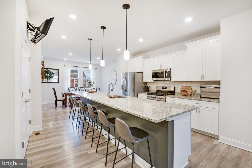 Absolutely lovely 4BR, 2 full and 2 half bath townhome in the much sought-after Parkside at Warfield community.  This home has been well maintained and is move-in ready.  The main level, with LVP flooring, features a center kitchen that provides a truly open floor plan with your DR and LR planking each side.  The kitchen has a huge island that seats 6, a gas stove, beautiful tiled backsplash, SS appliances, a very large pantry and plenty of cabinets and counter space. The large living room is filled with natural light from the windows, has a large custom closet for extra storage and access to your 18x10 composite deck.  The large dining room is bright with the natural light coming in from its 3 windows and can easily fit a DR table that seats 8. A powder room can be found tucked away off the dining room. Upstairs you will find the large primary suite with tray ceiling, a large walk in closet, and access to the primary suites private bath containing a separate water closet, double-bowl sink and walk-in shower with a seat. Two additional BRs with good size closets,  your family bath with a tub shower, and your laundry area are also located on this floor.  Notice the large green space outside your front door (unique to this court only) as you enter the house from the lower level into the foyer. Off the foyer is the  4th BR with a full closet and 2 large, full-sized windows. The half bath is located right outside the BR. This community has so much to offer with its quick access to Rt.32 and Rt. 26, community playground, and walking paths.  Take a short walk through the community's dedicated walking tunnel to Millard Cooper park and let your kids enjoy the splash pad during the summer, a fun zipline and other play equipment.  Downtown Sykesville, home to boutique shops, restaurants, and year-round community events, is also just a short walk using the same walking tunnel.