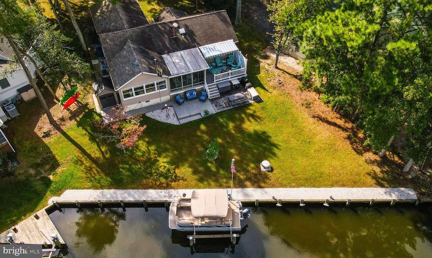 Immaculate home with the coveted, generous, waterfront luxury including a boat slip with lift.  This 3 bedroom home has everything.  When you enter you feel the pride in ownership as you look through your own private oasis on the water.  Every part of this house has been upgraded including gleaming and gorgeous countertops, upper-end cabinets and an island that is central to the home for an open feel that is great for entertaining and enjoying your private water views.  Freshly painted throughout. The floors are beautifully done with luxury vinyl plank and carpet.   The home sits on Ocean Pines' only aerated canal for cleaner water to enjoy.  Relax in your enclosed sunroom or your waterfront deck with an awning.  Other upgrades include newer precision garage door, a newer front door, garbage disposal, fridge, range/stove, awning, attic roof vent, leaf guard gutters, and encapsulated crawl space.  There is ample storage as well in your pull-down stair, floored attic.  Don't miss your chance to tour this beautiful, well-kept home on the water.  Furnishings and boat are negotiable