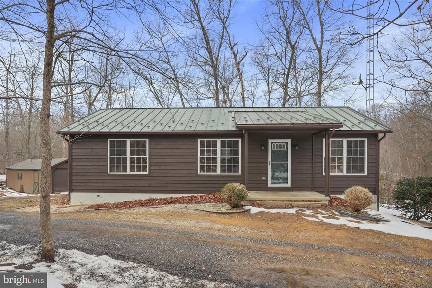 Nestled on 4 wooded acres, this charming 3-bedroom, 3-bath rancher offers the perfect blend of privacy and convenience in Hedgesville. The main level features a comfortable living room, an eat-in kitchen, a primary bedroom with an attached bath, and two bedrooms with a full hall bath. The partially finished basement expands your living space with a versatile room and a full bath—ideal for guests, a home office, or recreation area. Enjoy peaceful outdoor living from the screened-in back porch overlooking the serene, wooded setting. The property also includes a 1-car detached garage, perfect for parking, a workshop, or additional storage. Recent updates add peace of mind, including a new heat pump (2024), newer garage roof with 30-year architectural shingles (10/2025), freshly stained exterior (10/2025), and a newer kitchen stove (9/2025). Property is being sold as-is. Convenient to local amenities while offering tranquility and room to roam, this property is a wonderful place to call home. Schedule your showing today!
