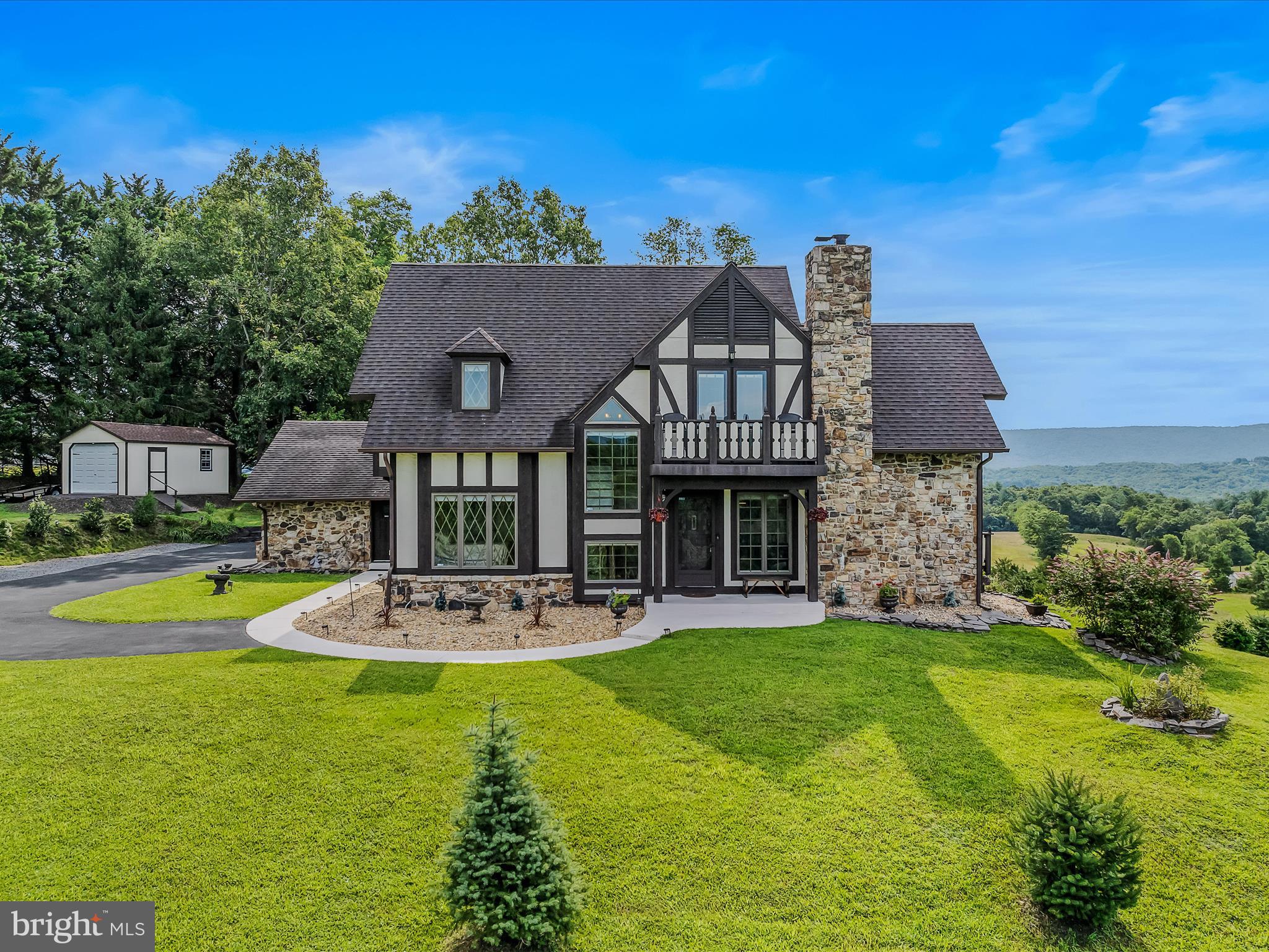 Welcome to 157 Top Meadow Lane, a truly awe-inspiring Tudor residence nestled on 4.23 acres, offering utterly breathtaking views that will leave you speechless. This magnificent property boasts an elegant entry foyer that sets the tone for sophistication, a living room with a soaring vaulted ceiling, stone fireplace, and expansive windows that frame the stunning scenery, a kitchen-dining area equipped with sleek stainless steel appliances, gorgeous granite countertops, and windows overlooking the deck and patio, perfect for savoring the beauty of nature. A loft with built in bookshelves and French doors that open to a balcony. Upper level office. Three spacious bedrooms, including a convenient main level bedroom, two full bathrooms, and a main level laundry area adjacent to the two-car garage and workshop, provide the ultimate in comfort and practicality. The partially finished basement offers endless possibilities for expansion and storage, while the attached deck and patio/pergola provide the perfect setting for unforgettable entertaining and relaxation. And, for the ultimate in convenience, a storage shed offers additional space for lawn care equipment and supplies.