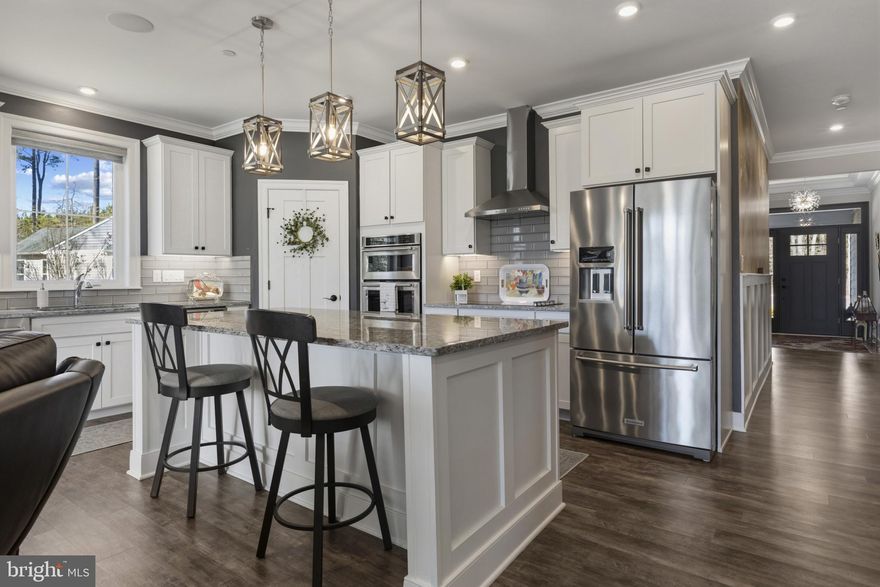 Welcome to this beautifully upgraded home at the Enclave in Prospect Bay, the Eastern Shore’s premier golf course community, offering main-level living, thoughtful design, and premium finishes throughout. Perfectly situated on a premium lot, this home blends comfort, style, and functionality both inside and out.
Located on a private lot next to the golf cart path with access to Prospect Bay’s 18-hole golf course, you are greeted by a welcoming covered front porch as you arrive. The main level features a spacious primary suite along with two additional bedrooms and two full baths, providing convenient single-level living. The primary suite showcases elegant tray ceilings and a luxurious ensuite bath with a frameless glass shower. Upstairs, a versatile loft with LVP flooring and surround sound offers flexible living space and includes a third full bath, giving it the potential to serve as an office, guest suite, or recreation room.
The upgraded kitchen is a standout, featuring enhanced cabinetry, KitchenAid appliances, under-cabinet lighting, and a stand-alone ice machine, making it as functional as it is beautiful. The kitchen opens to the living room and a dining area overlooking the paver patio and the 11th hole of Prospect Bay’s golf course. Also located on this level is a spacious office with barn doors. With direct access to the garage, the conveniently located laundry room continues the upscale finishes with upgraded cabinetry and granite countertops.
Designed with both style and entertaining in mind, the home features luxury vinyl plank flooring throughout the main living areas and primary bedroom, tray ceilings in the primary bedroom, dining room, kitchen, and living room, and crown molding in all main-level bedrooms and living spaces. Stylish board and batten molding and a custom wall mural in the main hallway and main-level office add distinctive character. Smart and modern touches include motorized blinds and a surround sound system in both the living room and loft.
The  two car garage is fully finished and thoughtfully upgraded, featuring complete interior painting, custom epoxy flooring,  a bump-out for your golf car and built-in shelving for additional storage. Above the garage, extended pull-down stairs provide convenient access to additional storage space. Outdoor living is just as impressive, with a sealed and coated front porch and a paver patio with a gas-lit fire pit, perfect for relaxing evenings or entertaining guests. The community maintains the gardens and lawn, offering a true turn-key experience.
Located within the exclusive Enclave at Prospect Bay, residents enjoy access to a wealth of amenities including an 18-hole golf course with pro shop, driving range, tennis and pickleball courts, a members-only clubhouse with restaurant and bar, community pool, playground, private boat launch, and more. Whether you're seeking a full-time residence or a weekend escape, this golf course-view property offers an unmatched lifestyle in one of Maryland’s most prestigious communities.