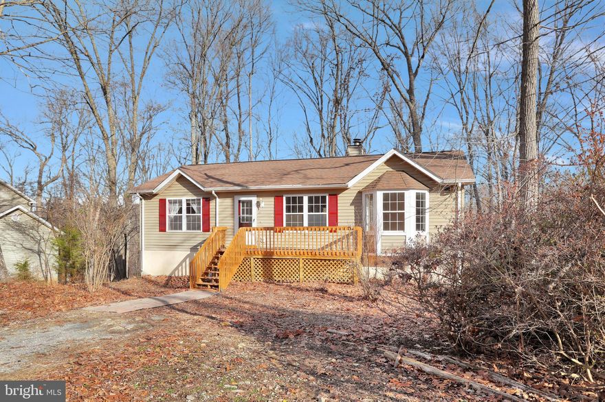 Raised rancher with front and back decks, overlooking trees.  Home features a breakfast room, dining area, kitchen with new appliances, open floor plan, living room has vaulted ceiling and wood burning fireplace.  Split bedroom design with primary bedroom en suite and guest rooms share the hall bath.  Downstairs there is a partially finished room with heat, closet, window and laundry area.  There is a full bath on the lower level.  Lots of storage, walkout basement with one car garage inside entry.  Parking in the front or side of the home.  Ready to move in!