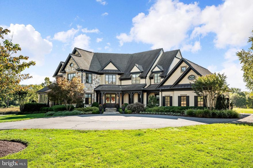 Welcome to a golfer’s dream retreat, set on a pristine one-acre homesite with commanding views of holes 9, 14, and 15 of the Jack Nicklaus Signature Golf Course. This luxurious residence, a former model home known as the "Nicklaus House," has been meticulously upgraded throughout, offering the ultimate in elegance, functionality, and modern design.
As you step into the grand foyer, you are greeted by a sweeping curved staircase and a new elegant chandelier. The main level showcases a formal dining room, a refined parlor, a private office with custom shelving, and a second office space for added versatility. The gourmet kitchen serves as the heart of the home, featuring a large center island with new quartz counters and backsplash, Sub-Zero and Wolf appliances, custom pantry with a barn door, and designer lighting throughout—perfect for both everyday living and stylish entertaining. The great room rises two stories high, with expansive windows and a stunning new quartz hearth and gas fireplace anchoring the space, while the adjoining family room offers a double-sided fireplace shared with the kitchen.
The three-car side-load garage has been outfitted with custom flooring, cabinetry, lockers, shelving, and three electric overhead storage lifts—perfect for organization and functionality.
The primary suite is a true sanctuary, boasting dual oversized walk-in closets, a new gas fireplace, and a spa-inspired bath with upgraded vanities and lighting. Each of the three additional bedrooms includes its own en-suite bathroom, all recently refreshed with new lighting and fixtures.
The finished basement is a showcase of craftsmanship, featuring a custom temperature-controlled wine cellar, a stylish family room with wood-beamed ceilings, and a full bar equipped with hidden storage, a two-drawer fridge, dishwasher, microwave, and ice machine. A new state-of-the-art golf simulator brings the fairway home, while a private bonus room with walk-in closet and spa-quality bath provides the perfect guest or au pair suite. Additional storage and a separate bathroom complete this exceptional level.
Every inch of this home has been thoughtfully upgraded to deliver the perfect blend of luxury, comfort, and functionality—all set within the exclusive, gated community of Creighton Farms. With sweeping golf course views and world-class amenities just outside your door, this property truly defines resort-style living.