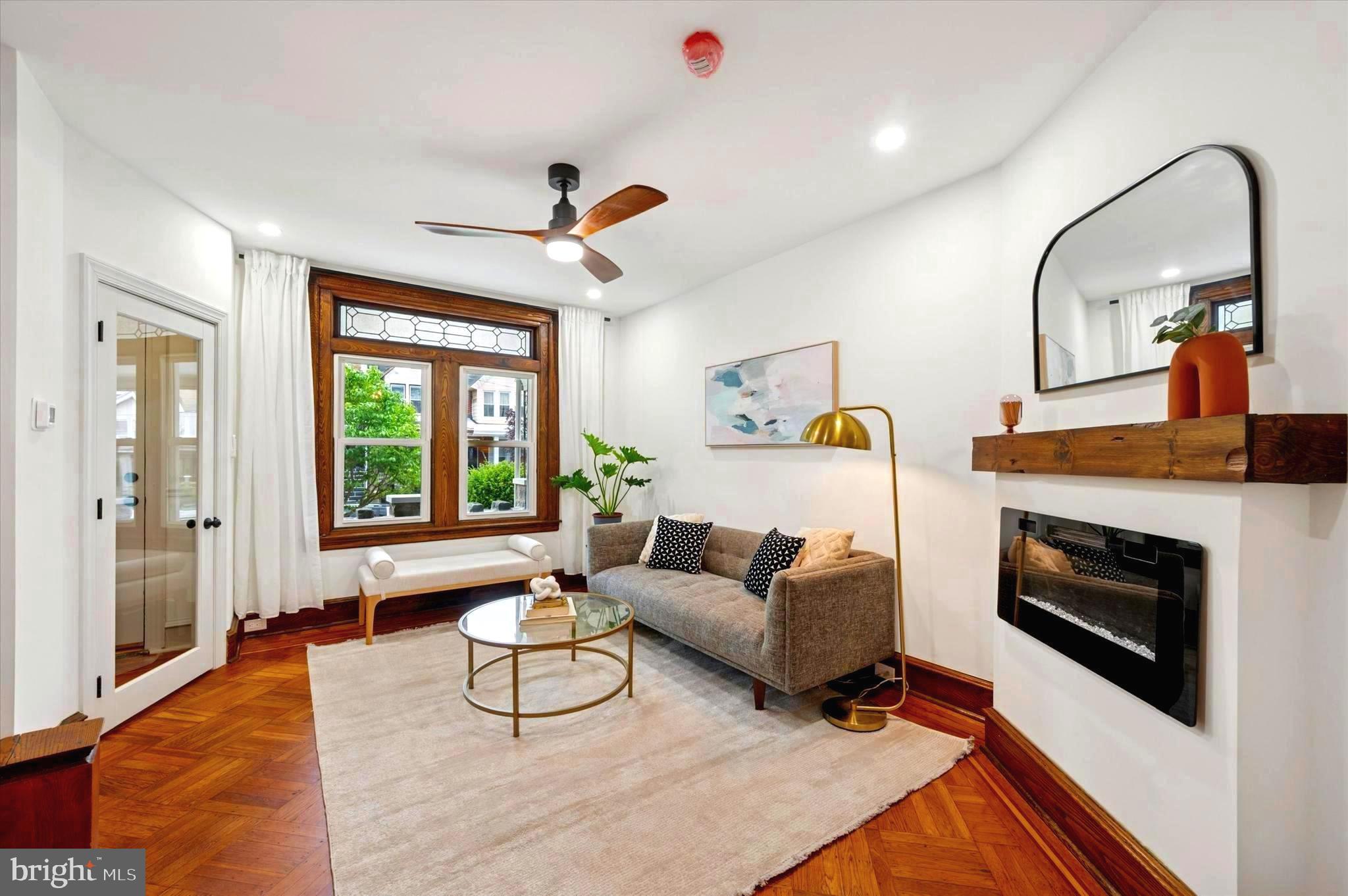 Are you looking for old world charm, original historic details AND modern updates like a brand-new roof, plumbing, electrical and HVAC? A needle in a haystack? Look no further and move right into this beautifully appointed home showcasing original details such as original parquet and hardwood flooring, gorgeous doors with original hardware that has been lovingly restored for the vintage detail lover in you. Located in sought-after Cobbs Creek on a quiet tree lined street, enjoy lazy afternoons on the front porch. The living room and dining areas are stunning with original zinc paned glass windows, parquet flooring throughout, a fireplace and dining area with space for both your dining table and sideboard. Tucked under the stairs is a half bath for your guests. The kitchen is modern yet classic with quartz countertops and new stainless appliances. Looking for a yard? Large yard with plenty of room for your grill, outdoor dining set, and garden.
The upstairs living quarters are comprised of three ample sized bedrooms that get fantastic light throughout the day. The primary bedroom has a soaring cathedral ceiling and two large closets. The rear bedroom gets light from two sides and has a large closet. The middle bedroom is perfect for a home office dual-purpose guest room. In the bath, you will find a skylight over the shower, a gorgeous vintage-style console vanity, and a tub. Adding to the living space is the finished basement with plenty of opportunity for your imagination. Use it as a den, screening room, office, gym, yoga room…this is a great space with a cozy fireplace, full bathroom, large laundry area with brand new washer and dryer, and access to the rear yard. Exceptional workmanship and care went into this home. New Electric, HVAC, roof, skylight, and plumbing. 12-year roof warranty transfers to buyer. Seller is offering a one-year home warranty. This home qualifies for closing cost assistance with participating lenders. Have your agent ask us about this.