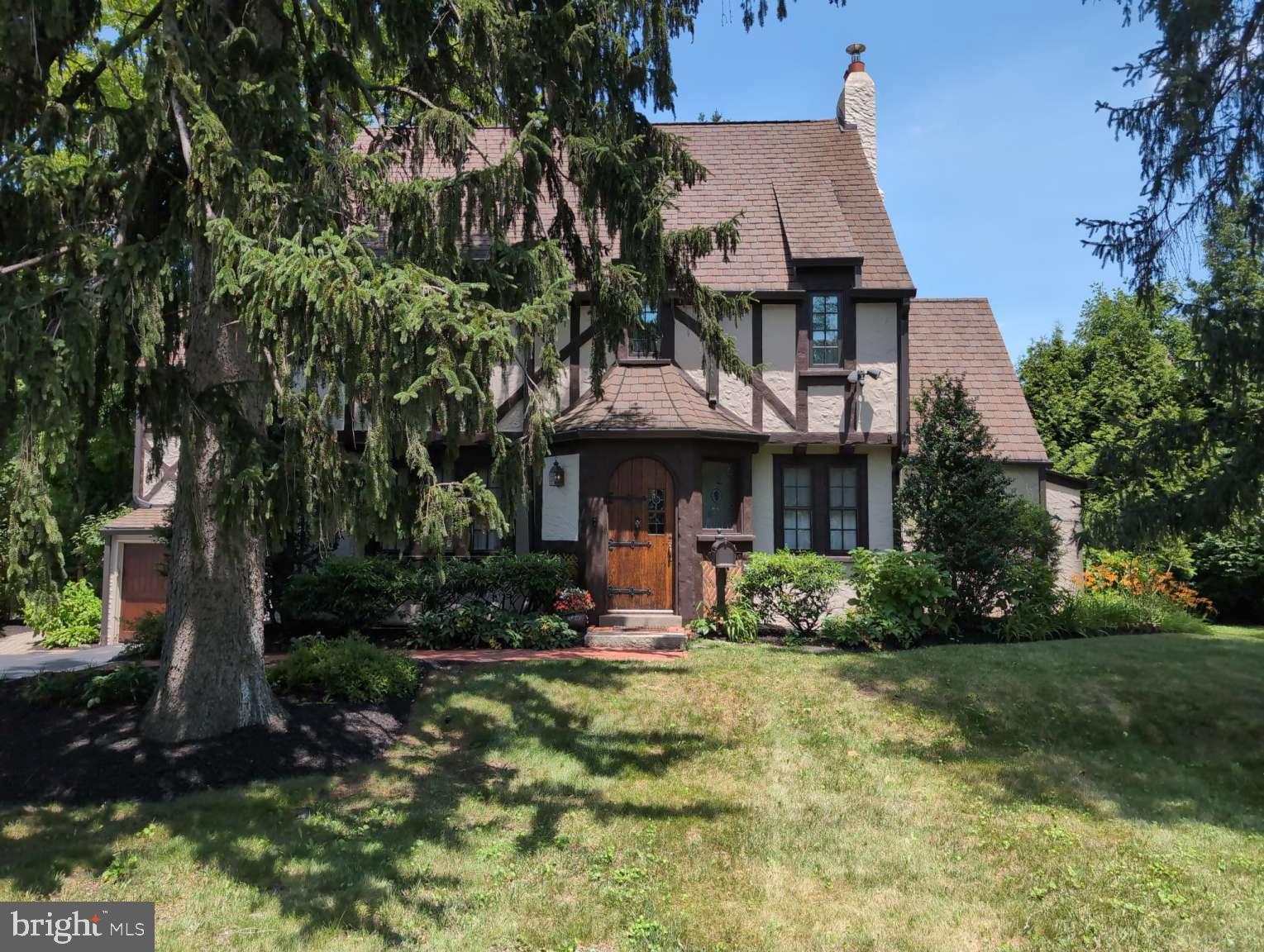Elegant English Tudor style home on a beautiful, professionally landscaped property. Homes in this cluster of coveted properties rarely come on the market as owners hold onto them for decades.
Walk a half block to commuter rail for a convenient, short ride to center city Philadelphia or to many stops on the Main Line, east and west. Walking distance to a farmer's market, restaurants, and downtown Wayne, and close to many shops, libraries, eateries, parks, trails, nightlife, and grocery stores. Well-located for easy access to many major highways. Top-rated Tredyffrin-Easttown schools and very low taxes.
The stunning, massive arched front door looks like it belongs on a venerable English castle. A handsome, custom electronic garage door enables convenient entry into the house from inside the garage. The garage has a 240v outlet for EV charging and power tools. A spacious, well-designed deck provides easy access from the kitchen for relaxation with privacy or for entertaining. Two staircases lead from the deck to the back lawn and to a large brick patio for barbecuing where there's plenty of space for a firepit, as well. Paver walkways provide access to the deck and patio from the driveway. Security lighting along the entire perimeter of the house lights the way with motion detection as one steps from each zone into the next. Security cameras allow for photo capture as well.
The eat-in kitchen with radiant heat in the floor draws everyone into that pleasing room. Included is a top-rated, ultra-quiet Miele dishwasher. Back stairs from the kitchen meet the main staircase for extra privacy. A full-size dining room allows for easy entertaining and has an elegant chandelier imported from Italy. A handsome wood inlay star medallion in the floor transitions from outside a half bathroom, down several oak stairs to a tiled laundry room. Here are a NEW top-rated washer and dryer with storage drawer pedestals as well as a utility sink with a high-volume faucet for quick filling. This laundry room has a back door to the patio and also leads inside to the full-size, unfinished basement. Off the living room is an enclosed porch/sunroom with large windows and room to accommodate an office setup. On the second floor, the master bedroom with ensuite bathroom adjoins a second bedroom which can be used as a nursery, sitting room or office. Off the hall is another full bathroom as well as a bedroom with an adjoining bonus room. On the third floor is an ensuite bedroom/bathroom with a clawfoot tub. An additional bonus room has numerous possibilities.