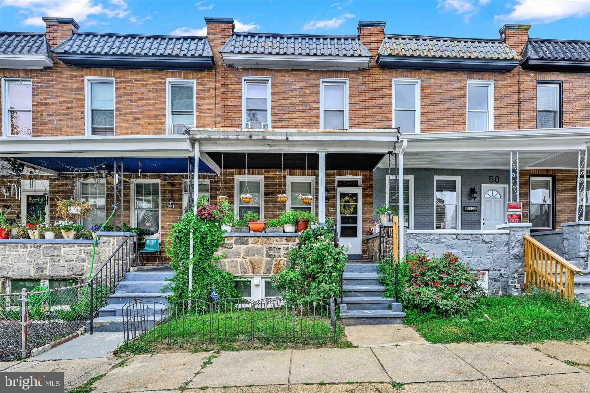 Welcome to this charming, well-kept brick rowhome offering timeless curb appeal and spacious living. A covered front porch with stone accents and lush greenery invites you inside to a sunlit living room with rich wood floors and a seamless flow into the dining area—perfect for hosting gatherings. The kitchen features ample cabinet storage, gas cooking, and direct access to the rear yard. Upstairs, you’ll find comfortable bedrooms with plenty of natural light and a full bath. The finished lower level expands your living space, offering a flexible area for guests, recreation, or a home office, along with laundry, storage, and a convenient half bath. Mechanical systems, including water heater and furnace, are easily accessible. Enjoy the fully fenced backyard, ideal for gardening, pets, or outdoor entertaining. Located near shopping, dining, parks, and public transportation, this home blends classic Baltimore charm with modern convenience. Perfect for first-time buyers or investors looking for a move-in-ready property!