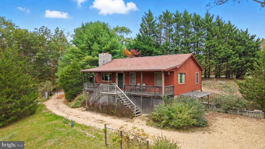 MAJOR PRICE IMPROVEMENT! Welcome home to a wooded retreat, tucked away near the top of a winding gravel roadway. Well-maintained 2BR/2BA rancher on 5+ wooded acres blends craftsmanship, comfort, and natural beauty.  This property offers tons of space to grow and create. Enjoy the light-filled living room with vaulted ceilings, custom wood beams, hardwood flooring, wood-accented walls, and wood-burning fireplace with handcrafted mantel. Dining room features coffered ceiling and matching beams. Custom kitchen boasts cabinetry and flooring made from reclaimed historic wood. Primary bath offers a large soaking Jacuzzi tub with custom wood paneling. Partially finished 1,100+ sq. ft. basement includes spacious den, rec room, walk-in cedar closet, and 5-year-old HVAC—ideal for home office with Frontier fiber optic internet available. Detached 2,300 sq. ft. woodworking shop includes dedicated metered power supply and sawdust collection system, plus additional smokehouse and woodshed. Enjoy walking trails, labeled garden beds, and a tranquil water fountain within the split rail fence. New roof shingles within past 5 years. Recently appraised and listed below appraised value - an exceptional opportunity to own a private homestead, craftsman’s retreat, or woodland sanctuary.