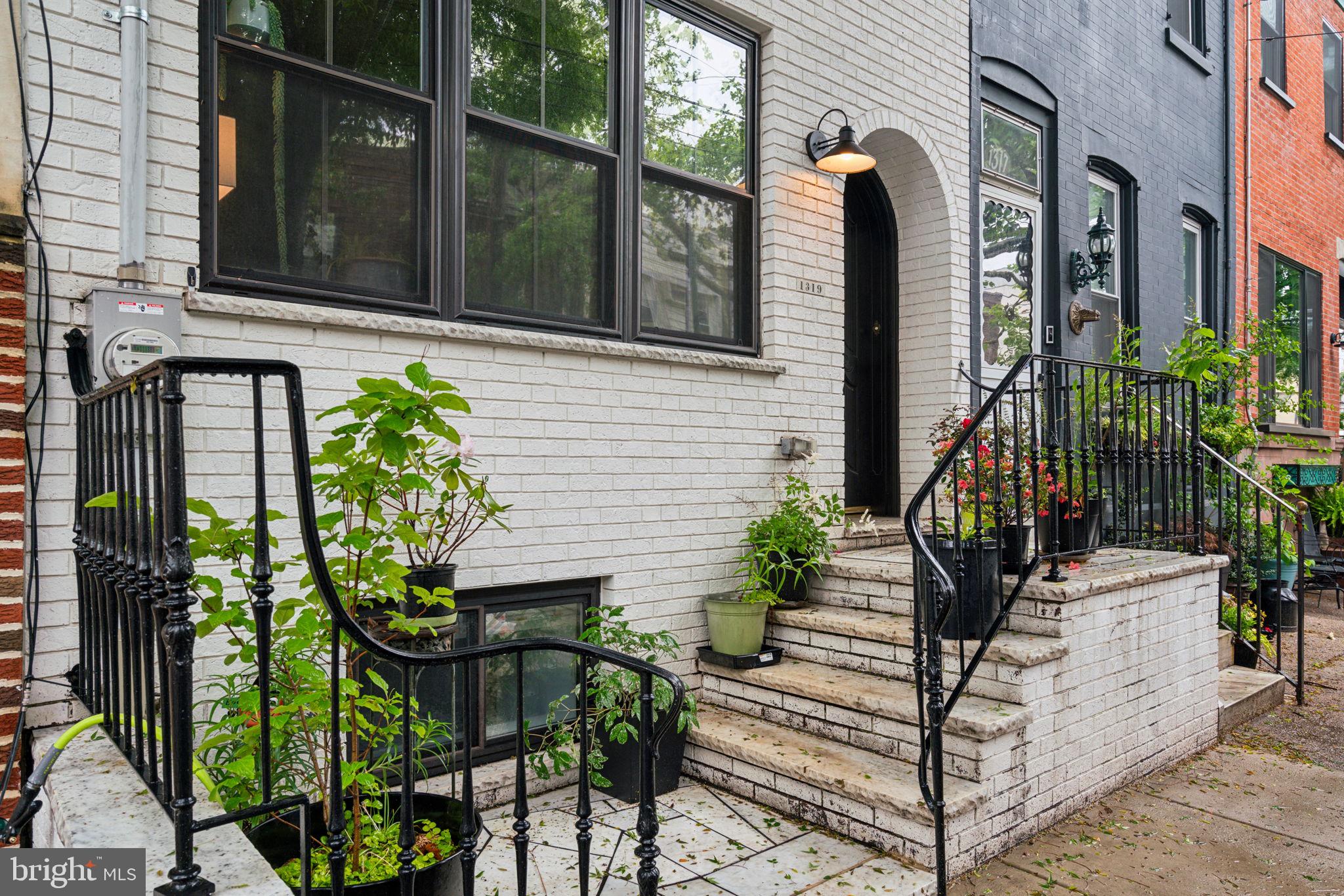 Welcome to 1319 Tasker Street, a standout with its signature white brick façade and inviting front stoop, this gracious and bright home is on one of Passyunk’s prettiest blocks. Step inside and discover a contemporary light-filled, meticulously maintained home. The open-concept ground floor features a spacious great room and convenient half bath—ideal for entertaining or relaxing. Original sweeping staircase anchors the space with timeless elegance, while the chef’s kitchen is fully outfitted with stainless steel appliances, stone countertops, a breakfast bar, and a kitchen sink that overlooks the beautifully upgraded rear yard. Perfect for gardening or grilling, this outdoor space is just waiting for your green thumb and BBQ skills. Upstairs, the primary suite boasts a crisp white en-suite bath, complemented by two additional bedrooms and a second full hall bath—offering flexibility for family, guests, or home office space. The basement is ¾ finished, providing a versatile bonus area, with the remaining ¼ dedicated to laundry and mechanicals. Come experience this crisp, bright Passyunk gem, where you can walk to everything this vibrant neighborhood has to offer—award-winning restaurants, shops, parks, and more. This home is ready to welcome you. Showings begin Sunday May 18th.