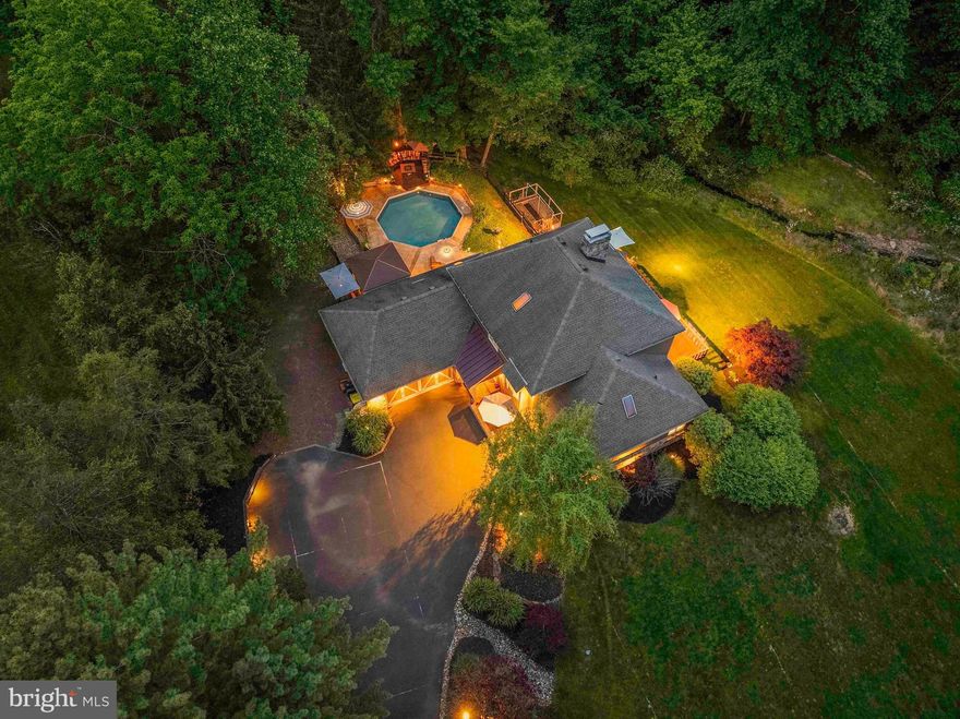 Welcome to 3097 Mill Road, a picturesque and private 3.67-acre estate nestled in the heart of Bucks County. Located just minutes from historic Doylestown, this custom 4-bedroom, 3 full bathroom home offers over 3,100 square feet of thoughtfully designed living space surrounded by nature's tranquility.  As you enter the home, you're greeted by warm hardwood floors, exposed wood beams, and a grand great room featuring a stunning floor-to-ceiling stone fireplace with a wood-burning stove. Large windows and French doors flood the space with natural light and offer seamless access to the expansive deck with the inground pool— perfect for outdoor dining, entertaining or simply enjoying the lush, manicured landscape and serene setting. Step into the beautifully updated kitchen, featuring modern cabinetry, stainless steel appliances, granite countertops, a stylish tile backsplash, a pantry, and a counter-height breakfast bar — perfect for casual dining. Just off the kitchen, a bright and airy sunroom opens onto the rear EP Henry paver patio and an expansive deck that overlooks the serene surroundings and the calming sounds of a nearby creek — an ideal setting for relaxation and outdoor entertaining. Adjacent to the kitchen is the formal dining room, spacious enough to accommodate both a dining table and hutch, offering a warm setting for family gatherings and dinner parties. Down the main hallway on the first floor, you'll find two generously sized bedrooms, each with ample closet space and large windows that provide scenic views of the property. A fully updated hall bathroom serves these bedrooms, equipped with laundry closet and a dedicated home office offers the perfect space for remote work or quiet study. Upstairs is reserved for the private primary suite with balcony overlooking the main living area and offers exceptional space and comfort. This serene retreat features a cozy wood-burning fireplace, a private balcony with views of the rear yard —perfect for enjoying your morning coffee — and an abundance of closet space. The en-suite bathroom includes a jetted soaking tub, a walk-in glass-enclosed shower, radiant heat floors and ample storage to meet all your needs. A versatile bonus room completes the upper level, and may serve as  a reading nook, sitting area, or personalized space. The finished lower level adds to the living space, featuring an additional bedroom, a spacious seating area, a walkout to a rear patio  and access to rear yard,  A full bathroom on this level is sure to impress, a large walk-in glass shower, radiant floor heat and generous cabinetry for all your essentials needs. Heading outdoors the exterior of this home is a true oasis, featuring lush landscaping, manicured gardens, a spacious deck, and stunning lighting for year-round enjoyment. Close to all amenities, shopping, restaurants, entertainment, major roads,  8 minutes to Doylestown, 8 Minutes to Lahaska, 15 minutes to New Hope  and convenient  to New Jersey and Philadelphia. Showings begin Friday 5/30/2025 at the open house 5-7pm.