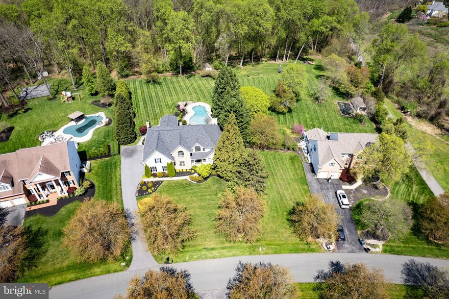 Stunning transitional home with a backyard oasis designed for entertainment! The private, 1.12 acre lot backs to preserve and features a heated pool with built-in hot tub; extensive hardscape with a bluestone patio, stone retaining walls and a custom fire-pit; lush landscaping and a flat back yard. An upgraded, low maintenance deck and relaxing screened porch seamlessly connect the indoor and outdoor spaces. The interior of the home is filled with natural light and features rich hardwood flooring throughout. The gourmet kitchen boasts re-finished cabinets, granite countertops, a custom backsplash, upgraded appliances including a gas cooktop and a spacious breakfast area.  The large family room of the kitchen features vaulted ceilings and a floor-to-ceiling stone fireplace. The impressive dining room with two story ceilings, custom trim, a designer chandelier and large windows overlooking the pool is the perfect place for entertaining your guests. The main level primary bedroom suite features cathedral ceilings, a gas fireplace, two walk-in closets and a fully renovated primary bath with stunning glass shower, free-standing soaking tub and custom double vanity with quartz countertops and plenty of storage.  A private living room, ideal for home office, upgraded half bath and a large laundry/mud room complete the main level.  A curved front staircase and private back staircase lead to the upper level. There are three spacious bedrooms on the upper level, all with ample closet space, and two full bathrooms. The spacious loft is a great space for casual living or a family office. The lower level features a great recreation room with upgraded plank flooring, custom stone work and a wet bar.  There is a full bath in the lower level and tons of storage space.  The three car garage with epoxy flooring is perfect for the car enthusiast. Fox Valley is conveniently located near commuter routes, features a neighborhood pool and tennis court and offers great community events!  Welcome Home!