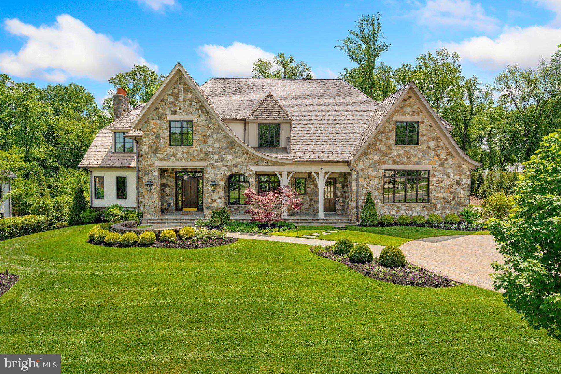 A premier offering in the prestigious enclave of Mackall Farms, this exceptional residence exhibits elevated craftsmanship and uncompromising luxury. A collaboration of McLean-based Winthrop Custom Builders, Andy Staszak Interiors, and Fine Landscapes by Charles Owen, the home seamlessly blends transitional elements with timeless design to create a gracious, yet refined living environment. Exterior elements incorporate natural field stone and painted brick, an EcoStar Empire Shake roof, masonry built chimneys, a saltwater pool, and a 4-Car Garage. An elevator accesses all floors of the home. The Main Level features both white oak hardwood and limestone floors as well as bespoke millwork and detailed trim work. Beyond the impressive 2-story Foyer lies the Great Room with gas Fireplace, stone mantel, quartersawn white oak custom built-ins, and two sets of French doors to the rear loggia. The formal Living Room with wet bar, elegant Dining Room, and a private white oak paneled Library with rear exterior access provide ideal work and entertaining spaces. A magnificent Kitchen with custom built inset cabinetry, soapstone countertops, Wolf/Sub-Zero appliances, and Morning Room with cathedral beamed ceiling and 180-degree views overlook the tranquil backyard. Conveniently, a generously sized Mudroom with direct garage access, 1 of 2 Laundry Rooms, a Half Bath, oversized storage spaces, and separate entrance completes the everyday living spaces. The Upper Level continues with white oak floors throughout. The expansive Primary Owner's retreat features a gas Fireplace, French doors to a private terrace, two custom designed Walk-In Closets, and a light-filled luxurious Bathroom finished with natural stone, a free standing soaking tub, two water closets, and two separate glass-enclosed showers. The secondary Bedroom Suite includes a large sitting room, Bathroom with separate water closet, and walk-in closet. The second Laundry Room, a rear staircase, and 2 additional Bedrooms, both ensuite and with walk-in closets, complete the Upper Level. The walk-out Lower Level is equally impressive with a fully outfitted custom wet bar, 1085-bottle wine cellar, Recreation Room with rustic beamed ceiling and gas Fireplace, state-of-the-art Home Theater, Fitness Room, a 5th Bedroom suite with Full Bath, and conditioned storage areas. The thoughtfully designed backyard living experience features a saltwater pool with spa and water feature, outdoor grill Kitchen, gas firepit, covered flagstone loggia with Fireplace, oversized patio, mature landscaping, and natural privacy screening, all perfect for relaxing, entertaining, alfresco dining, or gardening. The home is also outfitted with a Lutron lighting system, alarm system with cameras, commercial grade internet, and an irrigation system. Ideally located just 5 minutes to the GW Parkway or Beltway, 6 minutes to the Chain Bridge, 10 minutes to Tysons, 12 minutes to Arlington, and equidistant from Reagan and Dulles airports. Experience the splendor and ease of a turnkey offering available now.