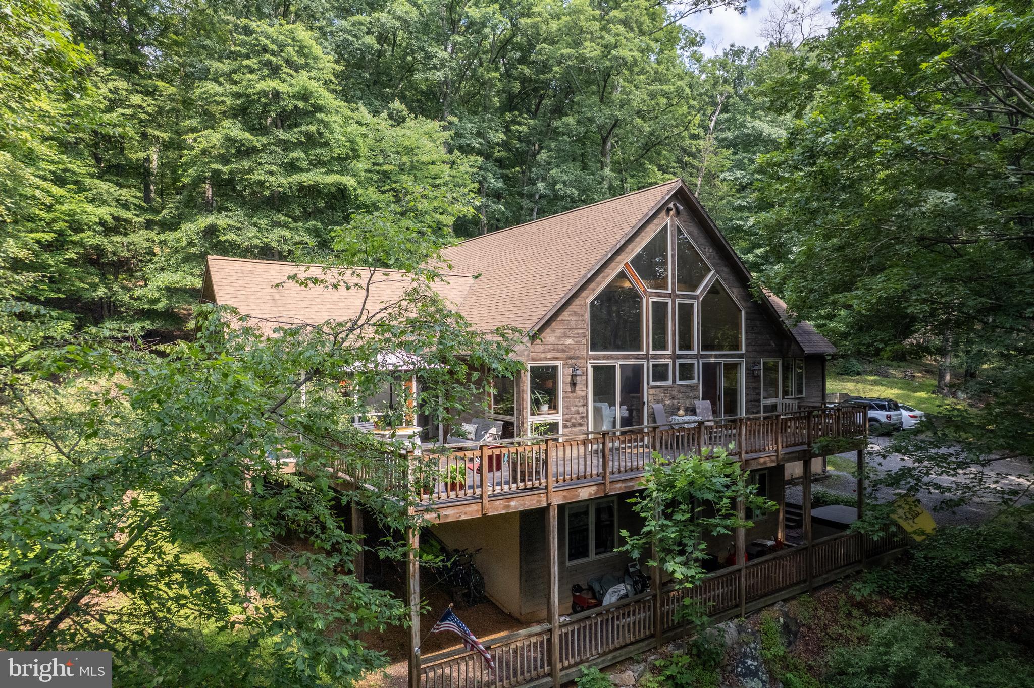 Stunning 5-Bedroom Mountain Chalet – 3,148 Sq Ft of Woodland Luxury Situated on 1.2 Acres
Tucked away in the serene woods of West Virginia, this beautiful 5-bedroom, 3-bath chalet offers 3,148 sq ft of spacious, well-designed living. Perfect as a full-time residence, vacation home, or investment property, this mountain retreat combines rustic elegance with modern comfort. Only a short walk to Coolfont Resort and Berkeley Springs Brewery. Located on Cacapon Mountain and only 5 miles from Berkeley Springs with elaborate restaurants and glorious spas and only 7 miles from Cacapon Resort State Park.
Step inside to soaring vaulted ceilings, a cozy stone fireplace, and an open-concept living area that flows seamlessly into a beautifully appointed kitchen—ideal for entertaining or quiet nights in. Large windows flood the space with natural light and provide breathtaking views of the surrounding forest.
Enjoy the outdoors from the expansive screened-in porch or relax on the large deck, perfect for morning coffee, evening sunsets, or weekend gatherings. The home features five generously sized bedrooms and three full baths, offering plenty of room for family and guests.
As part of a private community, you’ll also have access to amenities including a sparkling community pool—ideal for relaxing after a hike or a day of exploring nearby trails and natural attractions.
This is your chance to own a peaceful mountain retreat with all the space and comfort you’ve been dreaming of.
