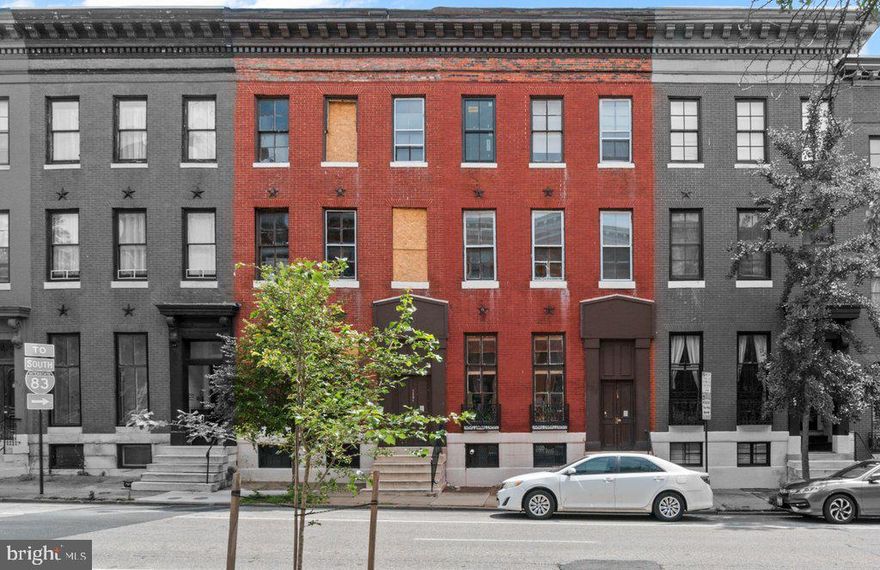 ● Offered at $700,000 — Just $58,333 per unit and $95 per sq. ft.
● 6 rented units + 6 gutted one-bedrooms — Fully licensed, separately metered units ready for redevelopment.
● $5,720 in current monthly rent — Offsets carrying costs while you plan your strategy.
● CHAP credit eligibility + tax assessment appeal — Reduce renovation costs with possible CHAP credits and reduce operating costs with a tax appeal.
937 North Calvert Interiors:
Kitchens are equipped with electric ranges. Four units have laminate countertops and wood cabinets; two have porcelain sinktops with metal cabinets. Bathrooms include steel tubs with ceramic tile or vinyl surrounds, along with and a mix of modern vanities or wall-mounted sinks.  Wood windows run throughout the building, with walls finished in plaster or wood paneling. Ceilings are plaster, suspended grid, or Celotex. Apartment 2R has 9″ x 9″ tile in both the living area and kitchen; all other units feature a mix of laminate, parquet, and vinyl tile flooring.

939 North Calvert Interior:
Damaged by fire, 939 North Calvert has been fully gutted to the studs. The building shares a similar footprint and layout with 937, offering six pre-existing apartment units across three floors. Emergency shoring has been completed with new star bolts installed; per a prior engineering recommendation, the buyer may add additional anchoring to further stabilize the front wall. This work enables the preservation of the wall and positions the property for potential CHAP tax credits. Renovation of 939 North Calvert will require a full permitting process, installation of a sprinkler system, and a new Use & Occupancy certificate. This is a substantial redevelopment project and best suited for an experienced operator.  Party walls include fire emergency doors connecting 939 to 937, providing necessary egress between the buildings.

Utilities and Mechanicals:
The buildings share a 400-amp electric service with 13 meters—one for each apartment plus a public service meter. Units in 937 have fuse panels and are individually metered, with tenants holding their own BGE accounts. One gas meter serves each buildings. Heat for 937 is provided by a central Columbia steam boiler with radiator distribution. Hot water for 937 comes from a central 75-gallon gas-fired water heater. 939 has a steam boiler and a gas-fired water heater, neither of which are currently operational. Observable plumbing supply lines are copper; observable drain lines are steel or PVC.

What’s Great About This Half-Rented, Half-Shell Value-Add Opportunity in Mount Vernon?
Located in one of Baltimore’s most walkable and culturally rich neighborhoods, this 12-unit opportunity sits just blocks from Penn Station, with access to Amtrak, and MARC trains.  Tenants are drawn to the area’s top-tier institutions—UB, MICA, Peabody—as well as museums, restaurants, and iconic performance venues like The Lyric and The Meyerhoff Symphony Hall. A Transit Score of 98 and year-round rental demand support long-term stability and above-average rents.

With six income-producing units generating $5,720/month, investors can offset holding costs while executing a phased renovation. The six-unit shell at 939 North Calvert shares a matching footprint and existing layout with 937 North Calvert, streamlining the redevelopment process. Fully renovated one-bedrooms are projected to lease at $1,500/month, with a stabilized ARV of $1,865,680. Buyers may also benefit from CHAP tax credits and can pursue a tax assessment appeal based on the current condition of 939, potentially reducing renovation and holding costs.

Cash flow, tax strategy, and long-term upside—this Mount Vernon asset is ready for a smart operator to unlock its full potential.