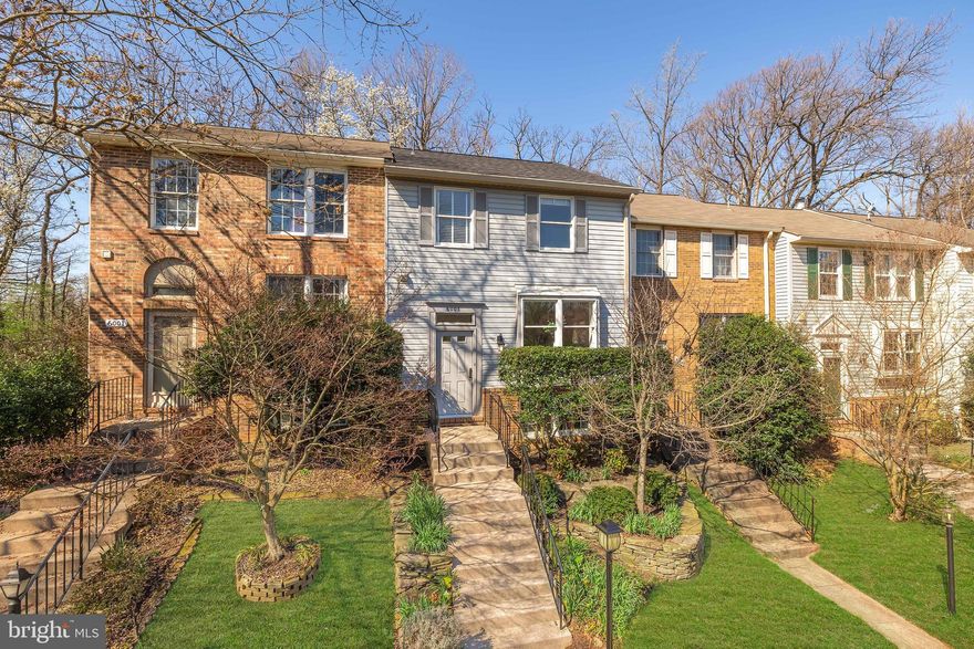 **Offer Deadline: Monday, 4/7 @ 6pm.** Nestled in the very back of Van Dorn Village, a private enclave of charming townhomes, is 6003 Chicory Place. Perched tall, a $15,000 landscaping package offers a resplendent approach to the home, past tiered layers and custom rock walls. Luxurious custom hand cut oak and wrought iron stair railings, replaced at a cost of $60,000, creates a formidable initial impression. They introduce comprehensively updated interiors, with new carpeting, paint, light fixtures, and hardware. A generous living room with a large double casement window is bright and cozy. The kitchen area is at the rear of the main level, with a level of separation enabling privacy yet maintaining flow. Tastefully functional, the kitchen features a timeless combination of high end cherry and cream cabinets with granite countertops. A full complement of stainless steel appliances, including a separate wine cooler, is present. An adjacent dining area and powder room complete the main level. Ascending the open staircase to the upper level reveals two bedrooms, both ample in scale. The primary suite boasts a spacious walk-in closet and tasteful wall of built-ins illuminated by abundant natural light flooding in. All baths have been renovated with granite, inlaid tile, and glass showers. The primary ensuite has a wide granite vanity. Facing forward, the second bedroom is serviced by a stylish hall bath featuring a walk-in shower with shower head and separate handheld wand. A third full bath, lined in subway tile, is found in the walkout lower level. The open concept recreation room has direct outdoor access. Fully-fenced for privacy and security, the rear yard comprises a large slate patio for lounging or dining al fresco. It backs to woods – a true luxury with townhome living and further setting the home apart. Additional improvements include a recently replaced roof and new HVAC condenser, while an assigned parking space and abundant visitor parking convey. Turnkey inside and out, and located in an incomparable Alexandria location close to major commuter routes, 6003 Chicory Place is livability exemplified.
