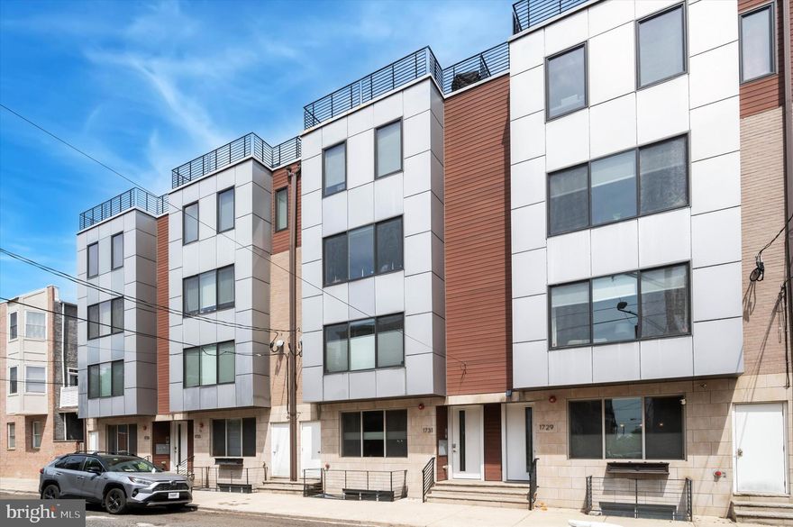 Experience the best of city living in this exceptional, custom-designed penthouse apartment in the heart of Graduate Hospital. Featuring nearly 1,330 sq ft of luxury across two spacious levels, this 2-bedroom, 2.5-bath residence is packed with high-end upgrades, smart features, and some of the most breathtaking skyline views in Philadelphia.
Step into a bright and airy open concept living space, where oversized windows flood the interior with natural light. The designer kitchen is a showstopper with Bosch and Samsung stainless steel appliances, Carrera quartz waterfall countertops, full slab backsplash, sleek high-gloss cabinetry, and a hidden walk-in pantry. Entertain in style with a built-in wine cooler and dramatic custom lighting throughout.
Upstairs, both bedrooms offer stunning skyline views and custom closets by California Closets. The spa-inspired bathrooms are finished with designer tile, floating vanities, rain showers, and premium fixtures. The spacious primary suite features an expansive walk-in closet and a luxurious en-suite bath with floor-to-ceiling tile and glass shower.
At the top level, enjoy your own private wet bar with a second wine fridge, perfect for entertaining. Slide open the doors to your private rooftop terrace, where panoramic 360-degree city views await—ideal for morning coffee or evening relaxation.
Additional features include smart lock entry and intercom system, whole-home Aquasana water filtration system, Samsung front-load washer and dryer and a built-in floor-to-ceiling bookcase. All of this located on a quiet, friendly block just steps from Carpenter Green Park, and a short walk to Rittenhouse Square, the Italian Market, and a wide selection of cafes, restaurants, and shops. Available for June move in. Schedule your tour today!