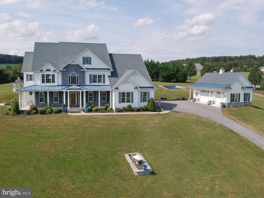 WOW ! WOW ! Almost 7000 sq. ft. of living space.  Beautiful 4BR,  5 1/2 BA,  6 Car Garage Colonial on over 2 acres, Cathedral Ceilings in Family Room and stone fireplace surrounded by large windows with Open Floor Plan and unbelievable sunsets to enjoy.  Large Gourmet kitchen with granite countertops with  lots of cabinetry and separate walk in pantry.  Master Bedroom with sitting area and fireplace to enjoy overlooking farmland.  Master Bath has heated flooring,  Huge In-Law Suite with 2nd Full Kitchen in basement, 2 more possible bedrooms and huge full bathroom with designer tile work.   Also a Theater Room.  Hardwood floors throughout.  Tile in all 5 Bathrooms,  Unbelievable Garden with a waterfall in the middle.  Large patio in back, rap around front porch. Full House generator. Very serene property surrounded by pastures sitting high on the hill with breath taking views of Carroll Co.  Additional laundry in fully finished basement. Lots of storage and a perfect home for entertaining. You won't want to miss this elegant home.