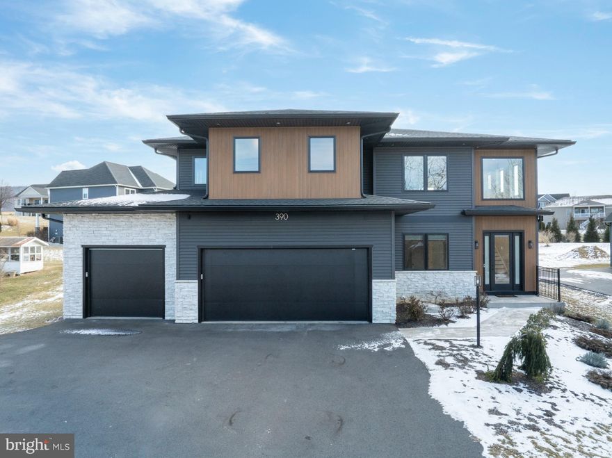 Completed in 2024, this striking modern home offers over 3,200 square feet of light-filled living space on just over half an acre. Clean lines, warm wood tones, and expansive windows define the design, creating a residence that feels intentional, elevated, and effortless to live in. The main level features a dramatic open-concept living area with soaring ceilings and wide-plank hardwood floors. A wall of windows floods the space with light, framing a built-in window seat and a striking modern stove. The kitchen anchors the home with an oversized island, custom cabinetry, and high-end appliances—designed to perform as beautifully as it looks. The first floor office could easily be used an additional bedroom, already equipped with a Murphy bed and adjacent full bath! Upstairs, the primary bedroom is bright and expansive. The attached bath offers a double vanity and tiled walk-in shower. Three additional bedrooms and well-finished baths provide flexible space for family, guests, or work-from-home needs. The lower level remains unfinished, providing the next owner with the flexibility to design additional living space tailored to their needs—whether a theater, gym, guest suite, or expanded recreation area. Outside, the fenced yard provides privacy and room to relax or play. A covered rear patio creates a beautiful outdoor space for dining, grilling, or unwinding. A three-car garage and whole-house generator add everyday convenience and peace of mind.