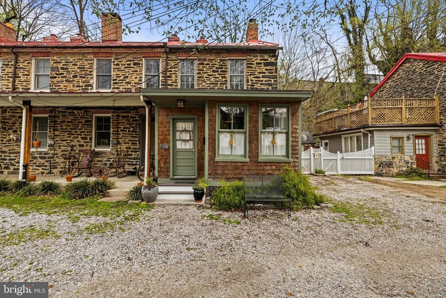Welcome to a thoughtfully reimagined piece of Baltimore History in the heart of Historic Hampden. Originally constructed in the 1840s as worker housing for the Whitehall Cotton Duck Mill, this timeless property seamlessly blends historic charm with modern comfort. Original hardwood floors and authentic stonework are a testament to the care and craftsmanship that define this home. A complete gut renovation in 2021 brought this historic gem into the present day, including a mudroom addition that could instead be used as a home office or creative studio. In the rear, a kitchen addition features soaring ceilings and is bathed in natural light from multiple skylights. The kitchen is a showstopper, sun-drenched and spacious, with an oversized pantry offering custom shelving and abundant storage space. Step into the inviting living room where exposed timber beams and a striking stone fireplace create a warm and rustic atmosphere. The adjacent dining area offers ample space to host gatherings and showcases another fireplace  that has been enhanced with a modern woodstove. On the first upper level, you'll find two well-appointed bedrooms and a full bath. Bedroom Two includes a charming homework or reading nook, offering serene views from the second story to the first. The second upper level features a large private bedroom with an ensuite bath including a tub and ample closet storage. Outside, enjoy a peaceful and beautifully landscaped backyard, ideal for morning coffee or evening relaxation. A one-car parking pad adds convenience. A handcrafted wood storage structure, crafted by the same artisan responsible for the stunning sliding barn door in Bedroom Two, is located on the side of the home. Situated just moments from local Hampden favorites, including the iconic "Avenue," the Clipper Mill Bike Path, and the scenic Jones Falls Trails, you’ll enjoy the perfect blend of urban lifestyle and outdoor adventure. Recent updates include: New kitchen appliances (2021), New washer, dryer, and water heater (2021), New 5-unit split HVAC system (2021), Custom pantry shelving by Ed Baldwin (2021), New stainless steel chimney lining system, top plate, rebuilt and regraded crown, exterior flashing, and woodstove (2022) and so much more! Don’t miss your opportunity to own this one-of-a-kind, meticulously restored piece of Baltimore history. Schedule your private tour today!