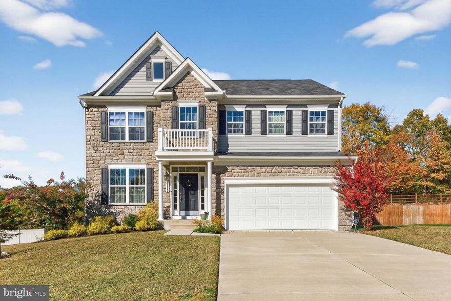 Newly Built Colonial with Stone Front on Half-Acre Lot – Modern elegance meets peaceful suburban living at 711 Yarrow Court, nestled in the desirable Manning Overlook community. Built in 2020 by Caruso Homes, this stunning Emory II model offers nearly 4,000 square feet of finished living space on a spacious 0.59-acre lot in a quiet cul-de-sac. Step through the inviting two-story foyer, where you’re greeted by a formal dining room on the left—perfect for hosting gatherings. The open-concept main level features a gourmet kitchen with stainless steel appliances, espresso cabinetry, granite countertops, and an extended island with seating for four. The kitchen flows seamlessly into a bright family room anchored by a cozy gas fireplace, while a convenient half bath adds function and style to the main level. Upstairs, you’ll find four generously sized bedrooms and two full baths, including a luxurious primary suite that feels like a private retreat. The suite boasts a spacious sitting area, an extended walk-in closet, and a spa-inspired bath with a soaking tub, separate shower, and dual vanities. The finished basement offers even more space with a large recreation room, fitness area, fifth bedroom, and full bath—ideal for guests or multi-generational living. Step outside to enjoy the deck overlooking a serene, wooded backyard, perfect for quiet mornings or entertaining under the stars. Additional highlights include a two-car garage, upper-level laundry, sprinkler system, and energy-efficient systems throughout. Located minutes from National Harbor, DC, and Alexandria, 711 Yarrow Ct provides easy access to commuter routes, shopping, and top-rated schools, making it an ideal choice.  This property qualifies for 100% USDA financing (subject to buyer eligibility). Additionally, buyers may take advantage of the Maryland Mortgage Program (MMP), which offers down payment and closing cost assistance, even for non-first-time buyers. MMP assistance is available with Conventional, FHA, VA, and USDA loan programs. Schedule your private tour today.