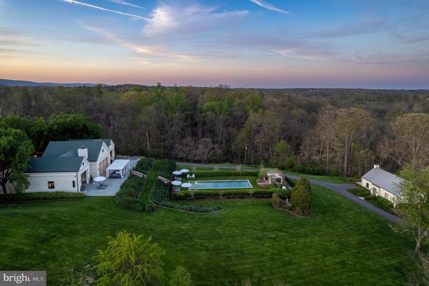 Set on an idyllic five-acre parcel and bordering a 400-acre private estate, this extraordinary Neoclassical Palladian villa offers nearly 6,000 sq feet of interior living space with spectacular views of the iconic Blue Ridge Mountains. Originally built in 1997 by esteemed architect Errol Adels, the home finished a two-year renovation in late 2017 and continues to be well maintained. Inside, a magnificent great room includes the gourmet kitchen, dining room and two seating areas that overlook the terrace and swimming pool. Each of the home’s five bedrooms - including two large ground level master suites - offer ensuite baths clad in floor to ceiling Carrara marble.  Additional noteworthy features include 10' custom doors, custom oak cabinetry, Miele and Sub-Zero appliances, Italian marble countertops, Lefroy Brooks fixtures and sconces, 180-year-old reclaimed wide-plank flooring, and custom millwork throughout. The 1,225 sq foot guest house has a spacious entertaining space with a concealed full kitchen, large bedroom and ensuite bath.  The pool, outdoor spaces and gardens are inviting and well proportioned.  Tasteful decor.  Completely private and in the middle of Virginia hunt country, Lily Pad is an ideal weekend or full-time residence.