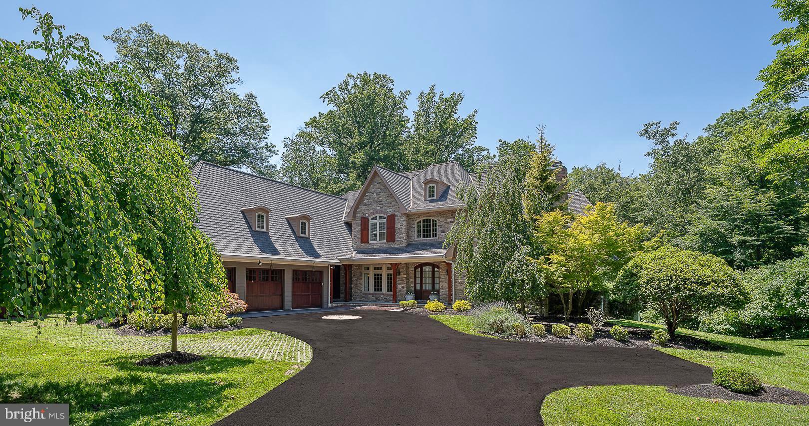 Welcome to 226 McClenaghan Mill Road in Prestigious Wynnewood – A Private 1.18-Acre Estate with Pool and Luxurious Amenities. This stunning 7,556-square-foot custom residence, located in the award-winning Lower Merion School District, offers an exceptional blend of classic charm and modern luxury. Nestled on a beautifully landscaped 1.18-acre lot with a gorgeous inground pool, this 5-bedroom, 5 full and 2 half-bathroom home is a true retreat. A grand two-story foyer greets you, flanked by a sun-drenched parlor with a gas fireplace and vaulted ceilings, and a formal dining room featuring exposed beams and elegant wainscoting. The butler’s pantry with a wine fridge connects to a chef’s dream kitchen—complete with dual islands, top-of-the-line appliances, a walk-in pantry, and a sunny breakfast area. The kitchen flows seamlessly into the expansive great room, featuring soaring vaulted ceilings with exposed beams, a floor-to-ceiling stone gas fireplace, and custom-built-ins. French doors open to a covered balcony that overlooks the pool and serene backyard. The first-floor primary suite is a true sanctuary, boasting a vaulted ceiling, sitting area, outfitted walk-in closet, and a luxurious ensuite bath with dual vanities, jetted tub, and oversized, walk-in shower. This level also offers two half bathrooms, a laundry room, a small office, and access to garage. Upstairs, three spacious bedroom suites each feature private ensuite bathrooms and outfitted, walk-in closets. Two include separate office or homework nooks—ideal for today’s lifestyle. The fully finished walk-out lower level is an entertainer’s dream: recreation room with French doors to the patio and pool, a gorgeous full wood bar, home gym, office, 5th bedroom, full bathroom, cedar closet, utility room, and abundant storage. Additional highlights include 2 HVAC systems with 5 zones, a whole-house generator. Award-winning Lower Merion Schools. Enjoy the convenient access to local parks, major roadways, and Suburban Square.
