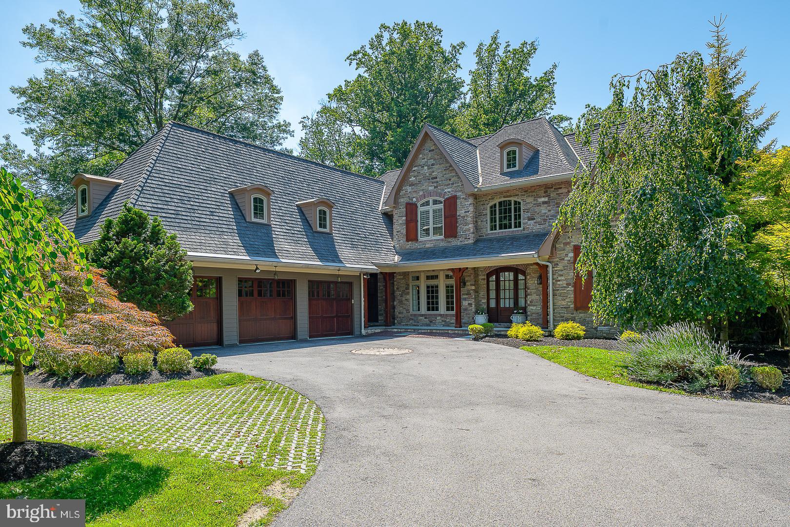 Welcome to 226 McClenaghan Mill Road in Prestigious Wynnewood – A Private 1.18-Acre Estate with Pool and Luxurious Amenities. This stunning 7,556-square-foot custom residence, located in the award-winning Lower Merion School District, offers an exceptional blend of classic charm and modern luxury. Nestled on a beautifully landscaped 1.18-acre lot with a gorgeous inground pool, this 5-bedroom, 5 full and 2 half-bathroom home is a true retreat. A grand two-story foyer greets you, flanked by a sun-drenched parlor with a gas fireplace and vaulted ceilings, and a formal dining room featuring exposed beams and elegant wainscoting. The butler’s pantry with a wine fridge connects to a chef’s dream kitchen—complete with dual islands, top-of-the-line appliances, a walk-in pantry, and a sunny breakfast area. The kitchen flows seamlessly into the expansive great room, featuring soaring vaulted ceilings with exposed beams, a floor-to-ceiling stone gas fireplace, and custom-built-ins. French doors open to a covered balcony that overlooks the pool and serene backyard. The first-floor primary suite is a true sanctuary, boasting a vaulted ceiling, sitting area, outfitted walk-in closet, and a luxurious ensuite bath with dual vanities, jetted tub, and oversized, walk-in shower. This level also offers two half bathrooms, a laundry room, a small office, and access to garage. Upstairs, three spacious bedroom suites each feature private ensuite bathrooms and outfitted, walk-in closets. Two include separate office or homework nooks—ideal for today’s lifestyle. The fully finished walk-out lower level is an entertainer’s dream: recreation room with French doors to the patio and pool, a gorgeous full wood bar, home gym, office, 5th bedroom, full bathroom, cedar closet, utility room, and abundant storage. Additional highlights include 2 HVAC systems with 5 zones, a whole-house generator. Award-winning Lower Merion Schools. Enjoy the convenient access to local parks, major roadways, and Suburban Square.