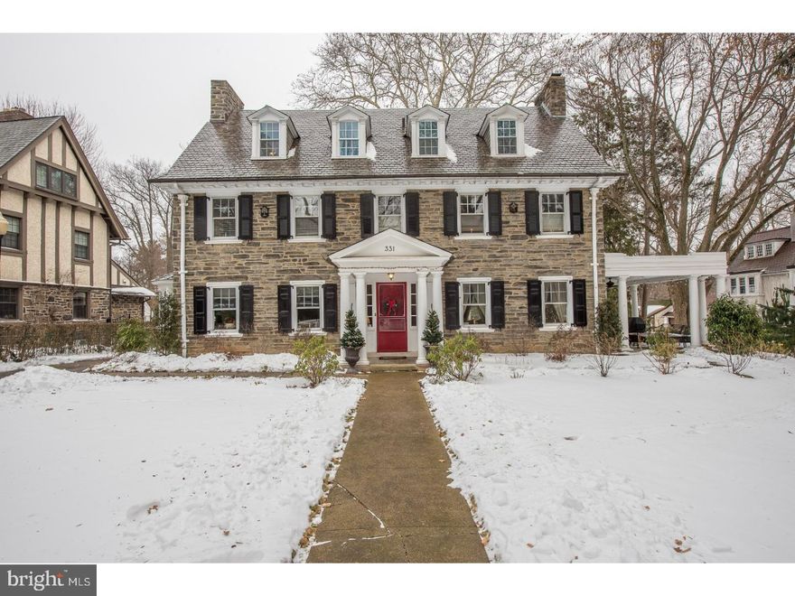 A classic center hall colonial in excellent condition with 1920's grandeur and scale, made of all hand cut Pennsylvania field stone with recently refurbished classic slate roof. Private drive to detached two car garage and parking apron. Enchanting flat property with gracious, private patio, covered south porch, professionally landscaped front, rear and side gardens and mature specimen trees. Nine-foot high ceilings, crown moldings, beautiful hardwood floors, gracious living room with fireplace and double french doors to covered porch. Large dining room with bow window seat built-in butler's pantry. Chef's kitchen with 3 undermount sinks, granite tops, double ovens, gas cooktop, and breakfast room. The kitchen opens to a large and bright family room addition with vaulted ceilings, beautiful built-ins, gas fireplace, atrium French doors with transom windows, and mud/laundry room; Six bedrooms, 4.5 baths. Master bedroom suite with H/H closets, private MBTH with twin bowl vanity, stall shower and jetted tub. Two additional second floor bedrooms share new, full marble hall bath with stall shower and tub. Full third floor has guest suite with private bath, another 2 bedrooms share the 4th full hall bath. Walk-in and cedar closets. Full, finished lower level with screening room, yoga/fitness studio, wine cellar, plentiful storage and newer mechanicals including new central air. Property is well-located within the best and most cherished, sidewalked family neighborhood on the Main Line.  Walking distance to SEPTA (3 mins) and Suburban Square (10 mins') walk. The best that Wynnewood, Narberth and Ardmore have to offer for markets, shopping, brewpubs, restaurants and convenience, all comfortably reached on foot.