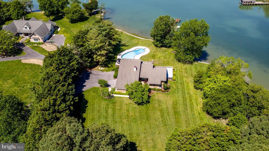 Tucked away on approximately 3 private acres along Plaindealing Creek just off the Tred Avon River, this striking waterfront retreat offers the perfect blend of Mid-Century Modern style, open-concept living, and exceptional Eastern Shore lifestyle amenities. With approximately 5’ MLW, a private dock with boat lift and floating dock, and sweeping water views from nearly every room, this property is designed for effortless waterfront living. The 3-bedroom residence features a desirable main-level primary suite with expansive creek views and direct access to the rear deck. The updated kitchen is a showpiece, centered around a massive U-shaped island with gas cooktop, abundant seating, and seamless flow into the light-filled living spaces. Hardwood flooring runs throughout most of the main level, while soaring ceilings and expansive windows create an airy, open feel that beautifully captures the surrounding waterfront scenery. Upstairs, two additional bedrooms share a full bath, accompanied by an open loft overlooking the foyer and living room — could be used as an office space or sitting area. Outdoor spaces are equally impressive. A sprawling rear deck stretches across the back of the home with access from the primary suite, living room, and kitchen, creating effortless indoor-outdoor living. The in-ground pool, mature landscaping, attached 2-car garage, and detached garage/workshop/storage building complete this exceptional waterfront offering. A rare opportunity to enjoy privacy, boating, and timeless architectural style in one of Talbot County’s most desirable waterfront settings.