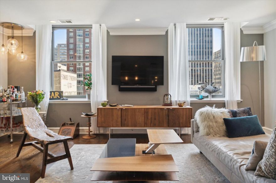 AVAILABLE THIS JUNE | Welcome to Residence 801 at The Belgravia in Rittenhouse Square! Step inside and be captivated by the timeless elegance of this ornate pre-war building. The Belgravia, with its Beaux-Arts architecture, showcases a stunning terracotta and granite facade with a statement iron canopy, setting it apart from its contemporaries on Chestnut Street.  On the building’s top floor, this meticulously upgraded unit awaits your arrival and offers an impressive open floor plan of over 1,300 square feet. Once inside, take note of the refinished hardwood floors which, with the handful of windows and recessed lights, lend to a warm and welcoming aesthetic. The upgraded kitchen, with its breakfast bar, stainless steel appliances, and pendant lights overlooks the dining area and living room, perfect for entertaining. The living room is expansive and offers the resident a variety of layout options. Complete with tasteful automated shades, a Sonos sound bar and recessed speakers, a smart thermostat, and app-controlled door locks, this modern home is also layered with conveniences. A marble powder room with a pedestal sink and contemporary sconces is accessed from the living room. A hallmark of this condo is that each bedroom has an en-suite marble bathroom — providing two proper suites for the resident and their guests. Each bedroom is outfitted with a closet and automated shades; one also offers a wall-mounted television and sound bar. Additional features include a front-loading washer and dryer, an August smart lock, and a handful of Alexa-controlled devices. Building amenities include a secure fob entry, a doorman, and an on-site fitness center. The building's surroundings are as lovely as the condo itself. Stop for fresh flowers, artisan cheeses, handmade chocolates, and the like each Saturday, at the farmer’s market on Rittenhouse Square. Grab a morning coffee at La Colombe, visit Parc for lunch, and stroll Philadelphia’s prime shopping corridor on nearby Walnut Street. We look forward to showing you around this exceptional property!