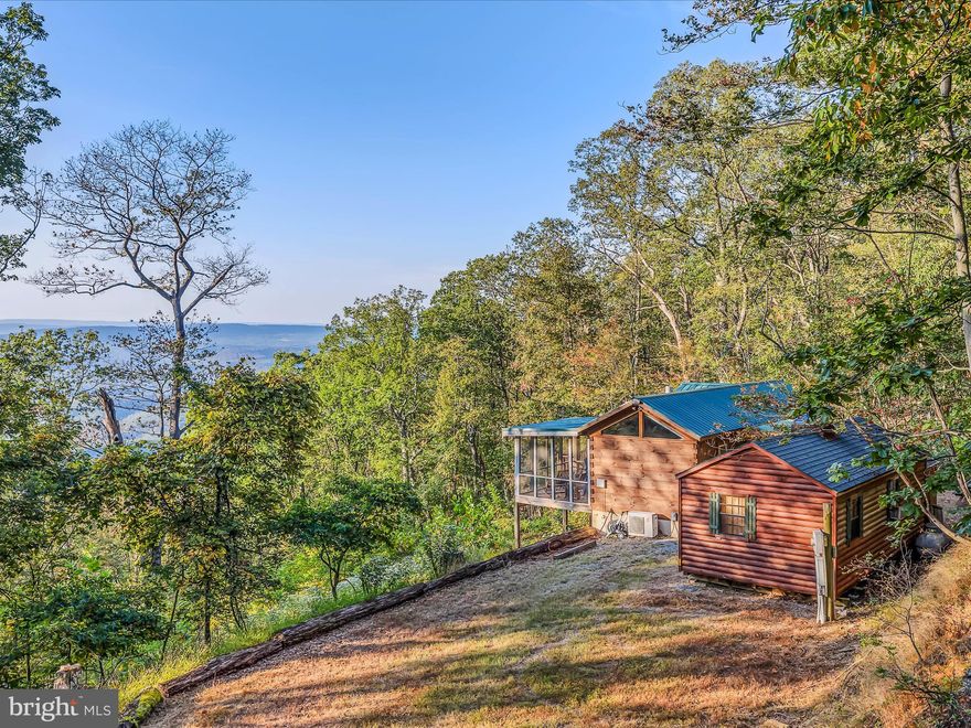 Remarkable views from this cabin on over 5 acres of land. Unrestricted acreage.  Cabin features a large deck and a guest quarters building.  Pine tongue and groove details inside with all of the normal comforts to relax and enjoy.  Features a mini split heating and cooling unit, gas fireplace, full kitchen, and washer and dryer.  A screened in porch is another awesome feature.  Can come fully furnished.  A must see!