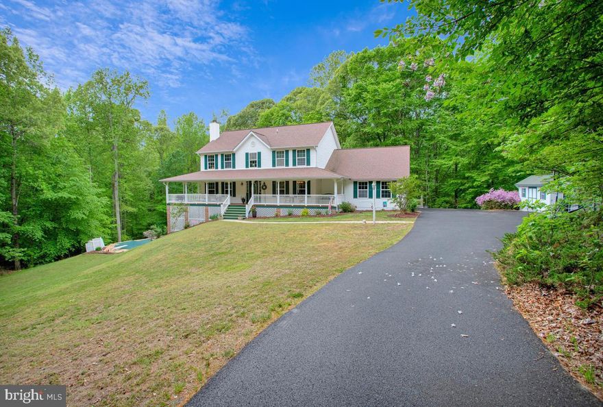 Private 2.5-acre wooded retreat-NO HOA! This beautiful Colonial offers the perfect blend of privacy and relaxation with a covered wrap around front porch and an open floor plan. Expansive multi-level, wrap-around deck overlooks the private pool and lush forest.   3 car sideload garage. Gorgeous hardwood floors span throughout the entire main level. The eat-in kitchen features granite countertops and new stainless steel appliances. 
Relax in the primary ensuite deep garden tub while gazing out of your huge picture window, which overlooks the serene woodlands. The 3 additional upstairs bedrooms are very spacious. A fully finished walk-out basement adds incredible value. The basement is complete with a bar/kitchenette and full bath—perfect for guests, entertaining, or for multigenerational living.
Updates include: all new appliances, resurfaced driveway 2025 and roof 2016 . This secluded sanctuary is move-in ready and built for entertaining! Easily commute to Pax River Naval Base, DC and Andrews AFB