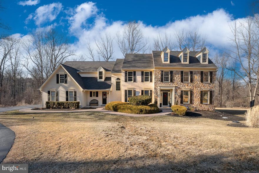 Welcome to 23 Great Woods Lane, a beautifully appointed 4/5 Bedroom, 3 1/2 Bath home in the sought-after Whitehorse neighborhood. Set on over 4 scenic acres, this elegant residence offers privacy and tranquility, nestled well off the road and backing to mature woodlands. A paver walkway leads to the welcoming front entrance, where refinished hardwood floors flow throughout the first floor. To the right is the formal Living Room featuring crown molding and picturesque views of the front yard, while an adjacent private Office offers built-in shelving and cabinetry - perfect for today's work at home environment.  To the left, the formal Dining Room with chair rail and "windowpane" molding is ideal for hosting holiday gatherings.  At the heart of the home is the spacious Family Room which boasts a vaulted ceiling, gas fireplace and large windows overlooking the woods.  The Family Room seamlessly connects to the eat-in Kitchen, which features granite countertops, an island with seating, gas cooking, pantry and ample cabinetry. A built-in desk provides a convenient workspace and there are sliding glass doors which lead out to a spacious deck - perfect for outdoor entertaining. There is a mudroom with a large coat closet, powder room, first floor laundry which leads to a 3-car garage and a secondary front entrance which leads to a charming, covered porch. The home also features both front and back staircases for easy access to the second level. Head upstairs to the Primary Suite, a private retreat with a sunlit Sitting area, tray ceiling, dual walk-in closets, and an ensuite Bath with vaulted ceilings, soaking tub, shower, dual vanities and a private linen closet. Three additional Bedrooms, each with ample closet space and ceiling fans share a well-appointed Hall Bath with a double vanity and a tub/shower combination.  A versatile Bonus Room offers options for a second Home Office, Exercise Room or 5th Bedroom.  Head downstairs to an expansive finished Basement with space for a billiards area, media lounge and home gym. A wet bar with seating, built-in refrigerator and dishwasher makes entertaining effortless, while a full Bathroom adds convenience. An unfinished storage area ensures plenty of room for organization. There is a new roof (2024) water heater (2024) and a whole house generator. This home is located in the award- winning Great Valley School District and is convenient to all major highways - a perfect home with all of the amenities for today's lifestyle!