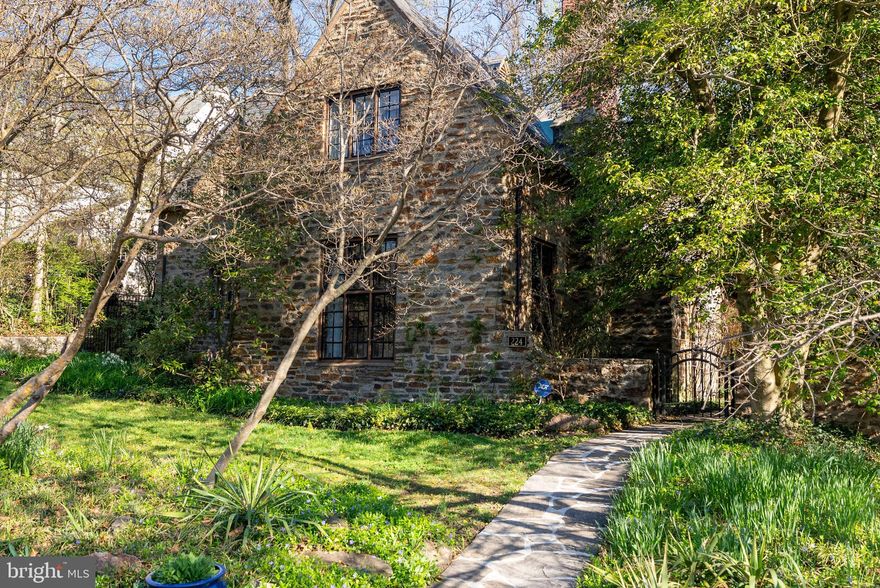 A rare opportunity to own a storybook Palmer & Lamdin stone cottage, tucked along one of Homeland’s quaintest streets.  Step inside to find a timeless residence that meticulously blends old-world charm with architectural integrity that's rarely found today.  The arched side entry leads into a dramatic two-story great room featuring beamed ceilings, an open hearth fireplace, custom millwork, original hardware, and rich hardwood floors.  Just a few steps up, a unique multi-level layout offers a primary suite flooded with natural light and custom closets.  This level conveniently hosts your kitchen and dining or sitting room, leading out to an intimate covered porch and patio, perfectly situated for entertaining.  The upper level offers 3 additional bedrooms, including a cozy room adorned with a fireplace, an additional ensuite, full hall bath, and home office with charming architectural lines.  Set on a beautifully landscaped and private .3-acre lot, the property is surrounded by a woodland garden, designed by the celebrated landscape architect Wolfgang Oehme.  Meandering stone paths, mature plantings, and curated natural elements create a serene setting that feels both secluded and enchanting.  You can find the original garden plans thoughtfully framed inside the home.   224 Tunbridge is a truly special property, awaiting its next stewards who appreciate architecture, history, and a sense of place.
