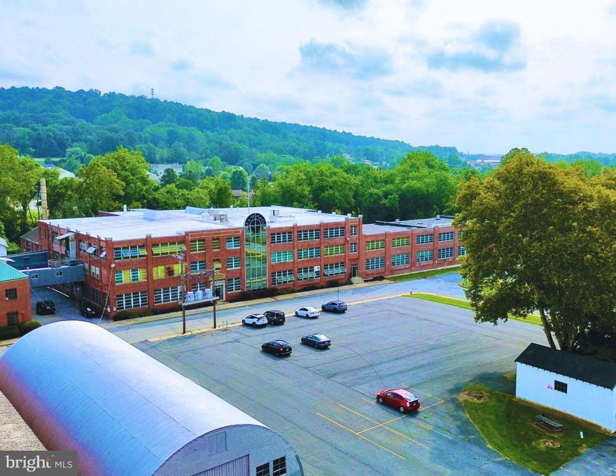 The F&M Hat Co Property has been a piece of Denver history for over 100 years! This property has been a hat manufacturing facility, once utilizing all 3 floors, the outbuildings for storage and taking advantage of the creek that runs behind the property to supply water for wool processing. Now it is ripe for new life, adaptive reuse or new development. The sale includes three parcels: 103 Walnut Street, is the primary site with a ±195,530 SF building on 10.3 acres; 130 Walnut Street, a 1.1-acre parking lot with 72 striped parking spaces, a ±4,000 SF warehouse and ±480 SF garage; and 108 North 2nd Street, a 0.62-acre parking lot located one block from the primary site. Zoned Light Industrial, the main building features four dock doors, 3-phase/2,000-amp electric service, and public water and sewer along with supplemental well water. On-site parking includes the 72 striped spaces mentioned above plus an unstriped lot with capacity for multiple tractor-trailers. Situated in northeastern Lancaster County, Denver offers immediate access to the US-222 corridor and easy connectivity to the PA Turnpike (I-76). The borough functions as an efficient node within Eastern Pennsylvania’s distribution network. This site presents strong potential for adaptive reuse, redevelopment, or continued industrial and distribution use.