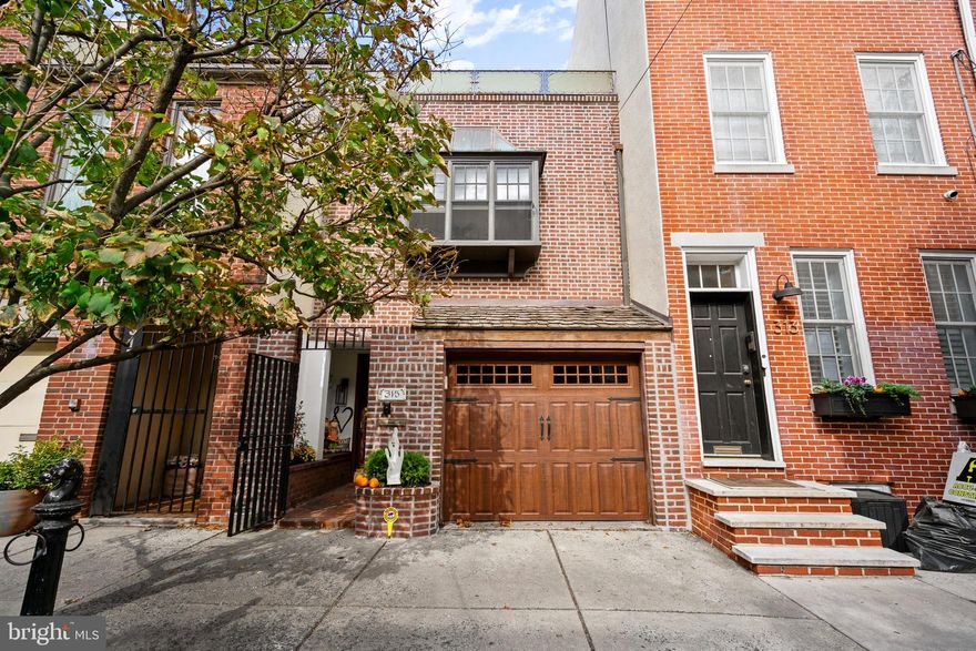 Welcome to 315 Fitzwater Street, a beautifully updated 3-bedroom, 2.5-bath home with a private garage—a rare find in the heart of Queen Village. This residence blends historic charm with modern comfort, offering inviting spaces, abundant natural light, and thoughtful updates throughout. Enter through the gated front entrance to find a welcoming main level with interior garage access, a powder room, laundry room, and a classic galley kitchen featuring stainless steel appliances, tile backsplash, and generous cabinetry. The kitchen opens to a dining area and bright sunroom, which flows seamlessly to the private rear patio—a perfect extension of the living space for morning coffee or summer gatherings. For warmer days, the sunroom includes automatic shades to keep the space cool and comfortable. The second floor features a spacious living room with warm wood floors, a beautiful fireplace with a detailed mantel, and stained-glass accents that add character and charm. Also on this level is the primary bedroom suite, complete with an en-suite bathroom and generous closet space. A built-in desk and shelving area provide a comfortable nook for work or reading. The third floor offers two additional bedrooms, a full hall bath, and a large skylight that fills the hallway with natural light—also equipped with automatic sun shades for comfort and light control. The front bedroom opens to a private terrace, an ideal spot to relax and enjoy the view. Since purchasing the home in 2022, the current owners have made a series of high-quality improvements, including full interior painting, new trim and solid wood doors, upgraded lighting, and refreshed bathrooms. The home’s major systems have also been modernized, with new heating and cooling systems installed in 2022 and 2025, as well as a new main roof (2023), balcony roof (2024), and repointed brick façade. The backyard has been completely reimagined with a new herringbone brick patio and refreshed landscaping, creating a low-maintenance and inviting outdoor retreat. Located within the Meredith School catchment, close to parks, cafes, and neighborhood favorites, 315 Fitzwater offers a rare opportunity to own a move-in-ready home that perfectly balances character, comfort, and convenience.