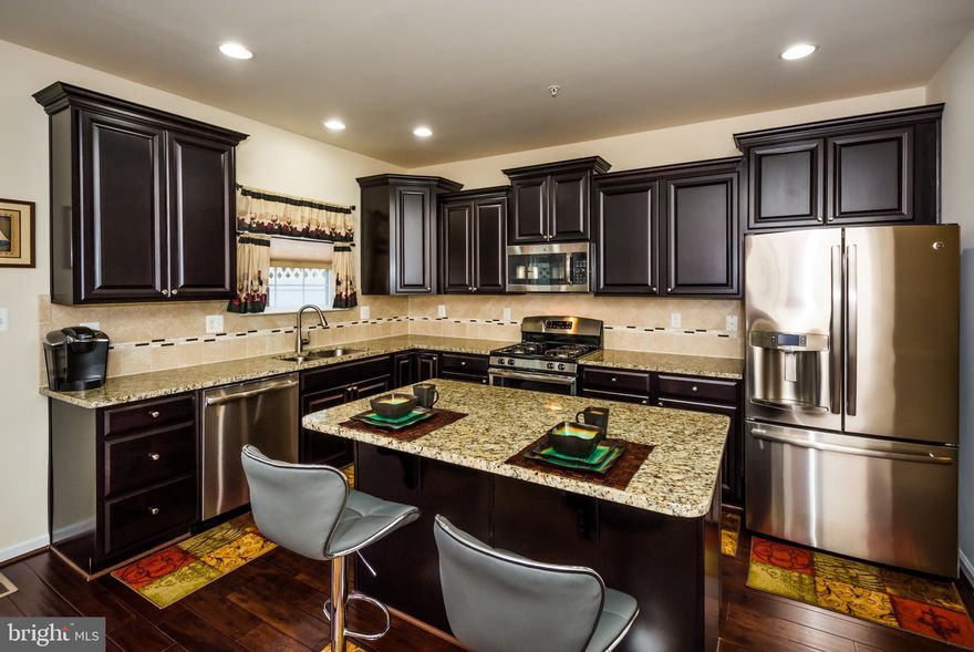 Spectacular END-unit townhome, impeccably maintained and professionally cleaned.  3 Bedrooms, 2 full and 2 half bathrooms, 1 car garage, fenced yard, and 2100+ finished sqft. Built in 2015 with an upgraded builder package, there are so many features to list! Including: Hardwood floors throughout the main-living area, recessed lighting throughout, and Large 2nd level Trex deck overlooking a nature retention area so there will be no building behind you. Spacious kitchen with granite countertops, breakfast bar island, upgraded 42" cabinets, luxury SS kitchen appliances that have been barely used-they are practically new! Upper level contains the master suite with Vaulted ceilings, walk-in closet, and can accommodate a bedroom set fit for a king. Large master bathroom with soaking tub under a window, shower stall, ceramic tile, dual sinks, and separate toilet area. Fully finished walkout level basement leading to the newly finished patio in the privately fenced backyard. With multiple levels of luxurious comfort on the inside, and the finest community amenities on the outside!  Community offers a swimming pool plus a kiddie pool, 24hr fitness center, 3 dog parks, picnic area, community garden, 4 playgrounds and walking trails! Convenient to 695 & 100 for commuting Closely located to Ft Meade, Baltimore, major hwys, restaurants and shopping.