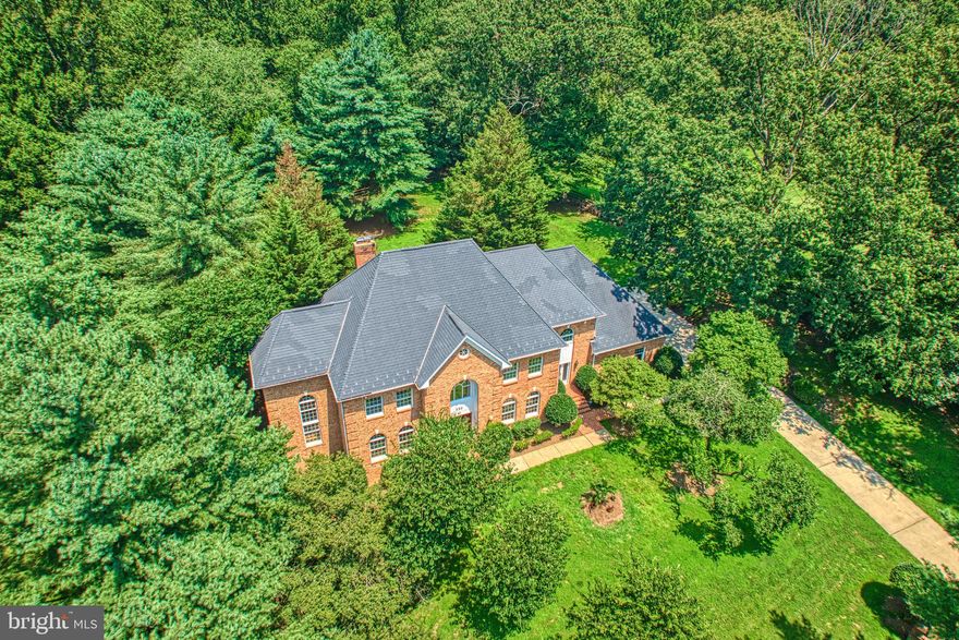 Enjoy the ultimate in privacy! Discover the charm of this stunning fully brick Colonial home, located  nearby the beautiful Riverbend Park on the Potomac River in the coveted community of Great Falls, VA., and located within the prestigious Langley High School pyramid. The property sits at the end of a cul-de-sac nestled on a sprawling, very private 1.72-acre lot, offering a perfect blend of elegance and comfort.  This  well maintained residence boasts approx. 6,000 sq. ft.. of finished living space, ideal for both entertaining and everyday living. Step inside to find a grand foyer with a curved staircase, leading to a spacious layout adorned with refinished hardwood floors, marble and ceramic flooring, and brand new carpeting. The heart of the home features a spacious kitchen equipped with stainless steel appliances, a double oven, and an inviting island, perfect for culinary enthusiasts. Enjoy meals in the eat-in kitchen or entertain in the formal dining room.  Gather in the family room, where a cozy brick wood-burning  fireplace sets the stage for intimate gatherings. Retreat to the spacious primary suite, and  large  ensuite  bathroom featuring two walk-in closets and a soaking tub and bidet.  Lounge in the attached primary bedroom entertainment room, fitted with a wet-bar and built-in cabinets. The fully finished walk-out basement with 2-story ceilings offers additional living space, with a recreation room, featuring a wood-burning fireplace, a full wet bar, a game room area, fitness room, storage room/workshop, guest room or additional home office, with ensuite bathroom--perfect for guests or in-law suite.  Enjoy serene views of the surrounding trees and woods from your expansive and private backyard deck, providing a peaceful escape.  Additional features include dental crown molding, a 2-story ceiling study on the main level with built-in bookshelves, french doors leading to rear deck,  a central vacuum system, laundry room, mud room, and a three-car side-entry garage with brand new insulated doors.  NO HOA! This home is not just a residence; it’s a lifestyle waiting to be embraced.  Don’t miss the opportunity to make this exquisite property your own!
---Recent updates: entire interior painted (June 2025), brand new carpet on the lower level and top floor level (July 2025), refinished hardwood floors on main level (June 2025), some updated lighting fixtures (July 2025), new insulated garage doors (July 2025), new water heater (June 2025), new sink in powder room (June 2025), deck re-stained (July 2025).  NOTE; (County tax record reflects 5 bedrooms, however the basement bonus room is not a legal bedroom and can be used as office, hobby room, guest room, etc.) (Septic perks for 4 bedrooms).