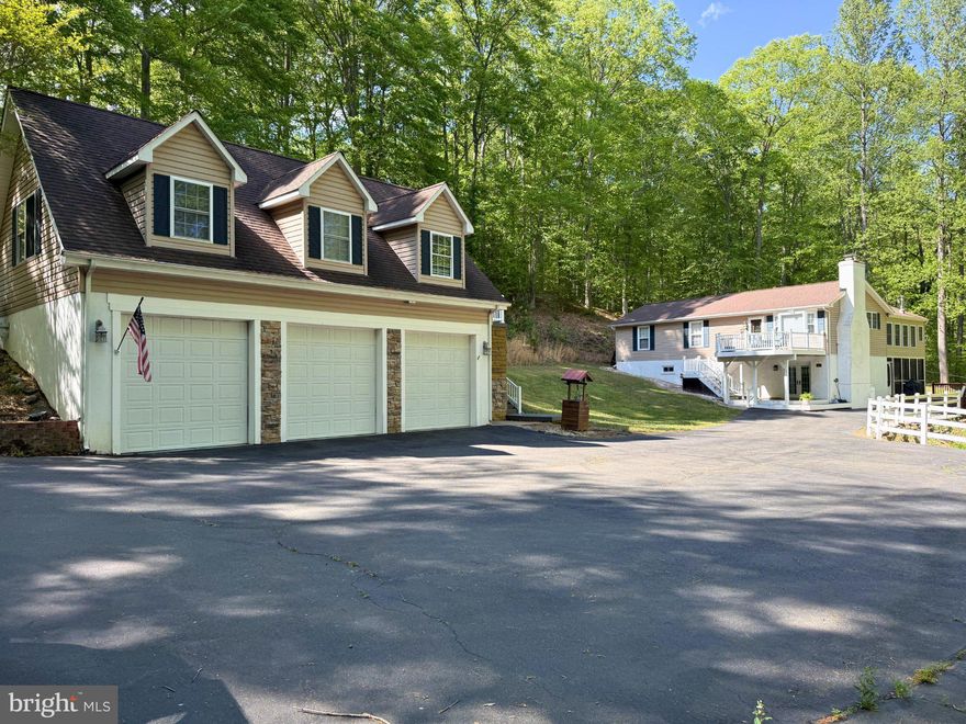 Welcome to your private wooded oasis in Stafford County, conveniently located just minutes from the Leeland VRE and commuter lots. Upon entering, you are greeted by an updated entryway that leads into this Raised Ranch, which combines modern touches with a cabin-like ambiance featuring wood walls, ceilings, and Carolina heart pine floors throughout. The renovated kitchen, equipped with stainless steel appliances (replaced 2020), granite countertops, and a spacious 7-foot island complete with a built-in wine cooler, also includes a coffee bar. The kitchen, living room, and dining area flow seamlessly together, creating an ideal space for entertaining. A gas fireplace with a stone front adds a welcoming touch for relaxation. Adjacent to the kitchen and dining area is a newly added sunroom, fully insulated and featuring luxury vinyl plank flooring, with a hookup available for a chiminea. Upstairs, you will find three bedrooms, including a primary suite with cedar closets and an ensuite Jack and Jill full bath/half bath, recently renovated in 2020 with granite countertops and a newly added tub/shower combination. Descend to the basement, which houses the laundry area, a fourth bedroom (NTC), a full bathroom, and a sitting area with a wood-burning stove, providing access to both the front and rear of the property. The property also includes a detached three-car garage with temperature control and a workbench that will remain. Above the garage is a 1,000-square-foot apartment; all utilities for the apartment are connected to the main house, with the exception of cable. The water heater and HVAC system were replaced 1.5 years ago, and there is a washer/dryer hookup available. On the property, you will find three storage sheds, with the closest shed to the house, located across from the garage, equipped with electricity. Additional features include a whole-house water filtration system and a gas-powered generator. The roof was replaced in 2020. Front deck on entrance of house was expanded and is trex.