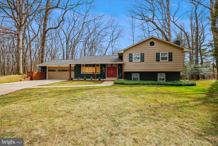 Magnificent Sweeping Wooded Views on an Incredible Lot in a Quiet Cul-de-Sac! This sprawling colonial sits on a 0.59-acre lot backing to North Branch Park, offering breathtaking wooded views and a rare two-car garage. Originally built in 1973, this impressive five-bedroom, 3.5-bath home has been tastefully renovated over the years, blending dramatic modern design with the spectacular natural landscape.

Exquisite details fill this home, including wood flooring, crown molding, updated fixtures, modern ceiling fans, and scenic outdoor spaces. The covered front entry welcomes you into an inviting foyer, leading to the elegant living room with recessed lighting, which opens to the formal dining room with deck access. The updated eat-in kitchen features a GE Café appliance package, solid surface countertops, a gas oven with six burners plus an additional cooktop with two burners, two paneled dishwashers, soft-close drawers, a bright breakfast area with a bay window, a buffet space, and access to the two-car garage. A modern half bath and a laundry closet complete this level. The attached garage includes an ancillary kitchen with a  second refrigerator, an oven, and cabinetry for extra storage and functionality.

The second level boasts four bedrooms and two beautifully appointed full bathrooms, with a clever sliding barn door at the top of the stairway for added privacy. The generous primary suite has a private entry, a sleek ceiling fan, a walk-in closet with organizing systems—including thoughtful shoe storage—plus an additional wall closet. The timeless renovated marble primary bathroom offers a glass-enclosed shower, floor-to-ceiling tiled walls, and a skylight. A bedroom/nursery/office with direct access to the primary suite adds convenience and flexibility.

The home features two light-filled lower levels. The first lower level includes a spacious family room with a brick accent wall, a fireplace with a mantle, and a large versatile fifth bedroom/playroom with a wardrobe system and access to a second deck with stunning wooded views. This level is complete with a renovated full bathroom and a second laundry. A few steps down, the second lower level reveals a surprisingly expansive recreation room with a large picture window and ample storage.

Ideally situated on a remarkable 25,854-square-foot lot, the property features mature trees, complementary landscaping, and incredible vistas. The backyard includes two separate decks with privacy wood slats, seamlessly blending classic architecture with its tranquil natural surroundings. This home backs to scenic North Branch Park and is just a short distance from the neighborhood swim club.

Conveniently located near Kemp Mill Swim Club, Northwest Branch Park, Wheaton Regional Park, Wheaton Ice Arena, horseback riding trails, biking and walking paths, and the Wheaton Library, this home also provides quick access to public transportation and shopping at Kemp Mill Shopping Center. With easy access to Georgia Avenue and Columbia Pike, this home offers the perfect balance of natural beauty and suburban convenience.