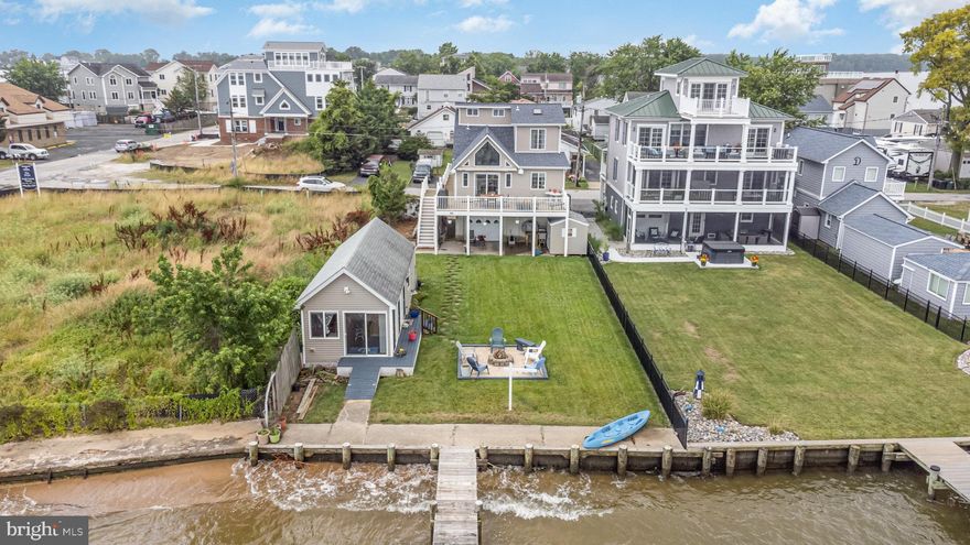 Welcome to paradise at Millers Island! This waterfront home boasts a truly idyllic location where life imitates vacation. Step inside and be captivated by the redesigned open floor plan featuring Cherry Hardwood flooring throughout the living space and kitchen, complemented by elegant cabinetry and countertops. Prepare to be mesmerized by the breathtaking panoramic views of both sunrise and sunset from this exceptional property. Situated on the western shoreline of Baltimore County, you'll enjoy unobstructed vistas stretching from Hart/Miller Island to Pleasure Island State parks and even over to the Eastern Shore. The wildlife and boat scenery here is unparalleled, creating a tranquil oasis. The main house offers a comfortable retreat with a primary bedroom and primary bath suite, as well as an additional main level bedroom and full hall bath. But that's not all - this property also boasts a rare and valuable feature: a grandfathered in accessory dwelling unit. Currently designed as a waterfront clubhouse with a full bath, it presents an opportunity to easily convert it into a third bedroom with a Murphy Bed setup, or alternatively, install a wall to create a fully enclosed third bedroom. The outdoor space is equally impressive. The magnificent waterfront side yard beckons you to gather around the firepit or engage in backyard games on the sprawling lawn. At certain tides, a private beach just off the wooden bulkhead provides a refreshing retreat for all ages. For water enthusiasts, a wooden pier extends 90 feet out into the water and offers two PWC or small electric boat lifts. Additionally, an 8 to 10k electric full-size motorized boat lift eagerly awaits your newest watercraft. Don't miss your chance to own this remarkable Millers Island waterfront home, complete with a grandfathered in accessory dwelling unit. Experience the beauty of nature, the serenity of the surroundings, and the joy of living in a place where every day feels like a vacation. The main house has a 3 year young Architectural roof system as well a 5 year or younger AC/heat pump system. Contact us or your agent today to schedule your private tour and make this paradise your own. Property square footage differs from what the tax record displays. The upper two fully finished levels above the foundation measure out on the floor plan to be an approximate total of 1,304 sq. ft. The clubhouse/accessory dwelling unit on the floor plan measures out to approximately 511 sq. ft.