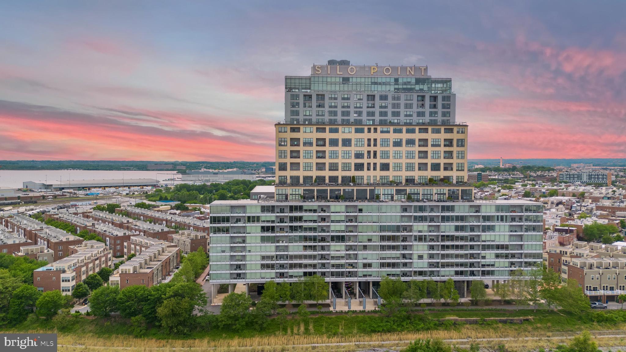Welcome to luxury living at Silo Point, one of Baltimore’s premier waterfront communities. This expansive 1,861-square-foot residence offers the perfect blend of modern elegance and urban convenience, featuring two spacious bedrooms and two and a half bathrooms.
From the moment you enter, you're greeted by soaring 10’3” ceilings and dramatic floor-to-ceiling windows that frame breathtaking panoramic views of the city skyline and harbor. Motorized blinds allow effortless control of light and privacy throughout the home.
The open-concept layout flows seamlessly from the living and dining areas to a private balcony—ideal for relaxing or entertaining. A chef’s kitchen anchors the space with granite countertops, stainless steel Viking appliances, and abundant cabinet storage. Rich hardwood flooring runs throughout the home, enhancing its warm, sophisticated ambiance.
The primary suite is a luxurious retreat, complete with a walk-in closet and a spa-inspired bath featuring dual vanities, a deep soaking tub, and a glass-enclosed shower. The second bedroom and ensuite bath offer flexibility for guests, office space, or additional living needs.
Additional highlights include in-unit laundry, two deeded garage parking spaces, and a dedicated storage unit, offering convenience and peace of mind.
Silo Point residents enjoy access to an impressive suite of amenities: a state-of-the-art fitness center, yoga studio, game and conference rooms, and the exclusive 19th-floor Sky Lounge—perfect for taking in the sunset over the harbor. A 24/7 front desk, secure entry system, and bike storage complete the lifestyle offering.
Ideally located in Locust Point, adjacent to Fort McHenry and the Baltimore Peninsula, Silo Point offers convenient access to commuter water taxi stops, public transportation, and major highways. The location provides close proximity to downtown Baltimore, Federal Hill, Camden Yards, and local dining, retail, and parks. BWI Airport is less than 20 minutes away, and Washington, DC is easily reachable for commuters and travelers alike. This residence combines modern comfort with historic charm and outstanding regional connectivity.
Don’t miss this rare opportunity to own in one of Baltimore’s most architecturally iconic communities
| PLEASE NOTE: These images have been virtually un-staged and may show slight discrepancies. (The primary walk-in closet does not have shelving as shown in the lower right and left of the images)|
