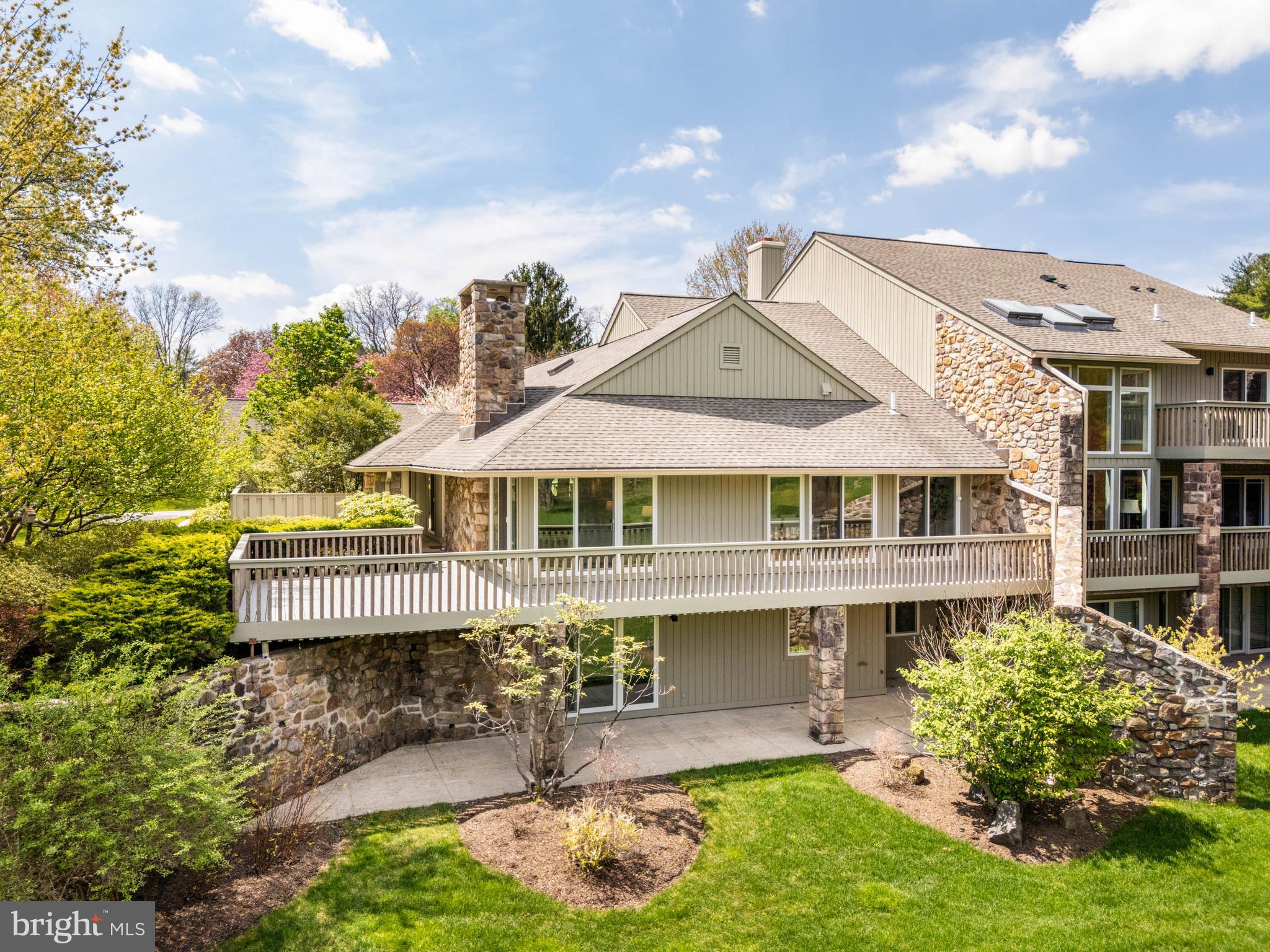 A rare opportunity to own the most desirable home in The Hermitage, a sought-after enclave in Bryn Mawr. Ideally positioned at the center of the neighborhood, this premier end-unit offers exceptional privacy and the community’s most coveted, uninterrupted panorama of nature—lush landscaping, mature trees, and a serene pond just beyond the flat, open backyard. Shielded by natural buffers, the home enjoys a sense of quiet seclusion, free from the disruption of passing traffic or neighborhood activity.
Fully renovated in 2019 by Spire Builders and designed by R.A. Hoffman Architects, the residence offers over 4,000 square feet of pristine, turnkey living. Every detail was curated for modern living, from the updated Trex deck and contemporary interiors to the versatile open backyard—perfect for a future pool, garden, or enclosed space for pets.
The main level presents a beautifully balanced layout, blending refined gathering spaces with private bedroom retreats. The expansive primary suite features three walk-in closets, en-suite laundry, a spa-inspired bath, and direct access to a secluded patio. A generous guest bedroom with en-suite bath offers comfort and privacy for visitors. A handsome library or office with custom built-in cabinetry and a wood-burning fireplace adds depth and warmth, while the spacious living room showcases a natural stone fireplace and sweeping views to the horizon. The large dining room flows seamlessly into a sleek, modern kitchen with walk-in pantry – perfect for entertaining or everyday living. A stylish and conveniently placed powder room completes the main floor.
The day-lit walkout garden level continues the home’s flexible living experience, offering another private guest bedroom with built-ins, a full bath, and a generous living or recreation space with custom built-ins and direct access to the rear grounds.
Four private parking spots include a two-car garage with an upper-level loft—ideal for a studio, gym, or creative workspace. Both the garage loft and walk-up attic offer potential for further customization and expansion, including the opportunity to create additional bedrooms with en-suite baths and natural light.
The Hermitage is more than just a place to live—it's a community designed and built around connection and enjoyment. Residents enjoy peaceful walking loops that wind through beautifully landscaped grounds, secluded tennis courts tucked among the trees, and charming outdoor features like gazebos, a scenic bridge, and a bench overlooking the picturesque pond—perfect for morning coffee or quiet reflection. It’s an active, friendly neighborhood that feels like a private retreat.
Set in a tranquil, park-like setting just minutes from downtown Bryn Mawr, this home blends timeless design, modern ease, and the rare combination of beauty, privacy, and possibility.