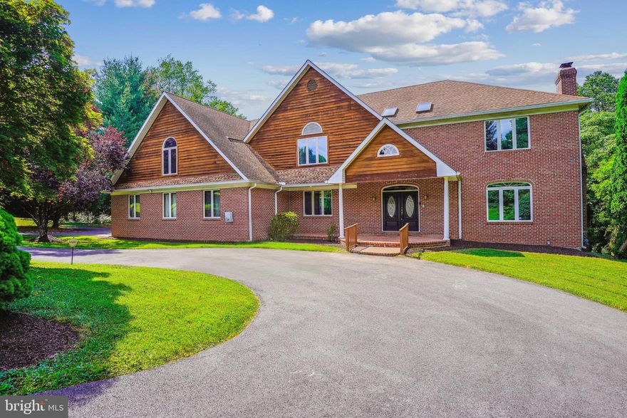 Custom all brick home with  8,500 square feet of interior space on private 2+ acre lot.  Grand foyer entrance with curved staircase and marble tile floor.  Spacious feeling in each room of the expansive home.  Hardwood flooring throughout most of the main level and upper levels.  Upper level open central hall.  Primary suite with sitting area, multiple walk-in closets and ensuite primary bathroom.   2nd bedroom with ensuite bathroom.  3rd bathroom w/ dedicated hall full bathroom.  4th and 5th upper level bedrooms share the 4th upper level full bathroom.  Full walk-out basement with 9 ft ceilings.  Large recreation room with fireplace.  3 bonus rooms.