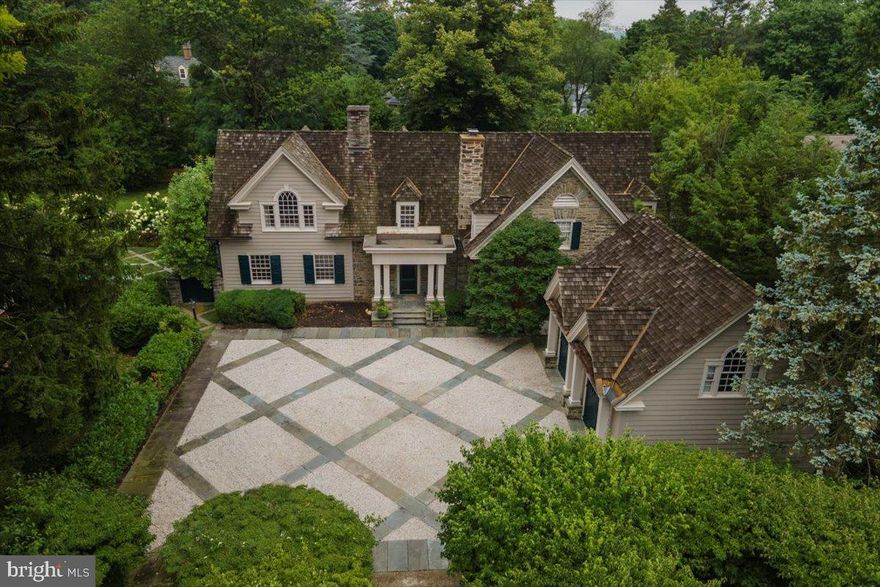 Extraordinary!  A deep winding driveway bordered by a cherry laurel orchard guides one to a home different from any other in the area.  The character of the 19th century flowing seamlessly into the comfort, light and efficiency of the 21st has created a one-of-a-kind 4 bedroom, 3 1/2 bathroom residence that epitomizes the warmth of  "home" and lifts one's spirits all at the same time.  In 1941, the owners transformed a handsome stone 1885 carriage house into a delightful home.  In 1989, a light-filled addition increased its size, value and usefulness and an oversized stone two-car garage with guest apartment above was built.  The current owners created a true 21st century primary suite with luxurious primary bath, upgraded many of the features of the house and brought an exemplary level of maintenance to the entire property.   FLOOR PLAN:  FIRST FLOOR:  The main entrance brings one into large gathering room that shares a wood-burning fireplace with the stunning airy living room.   With broad windows on 3 sides, the spacious living room is flooded with sunshine and offers a working fountain in the midst of a small indoor garden space below a large southwest-facing window.  1st floor powder room.  Deep hall closet.  Another hall closet served as the phone closet in 1941!  Center hall that leads either to the rear patio or to the stair foyer.   Formal dining room with chair rail and wall of windows.  Butler pantry with floor to ceiling  cabinetry, ice maker.  Chef's kitchen offers an abundance of cabinetry, a Viking dual fuel gas stove (fueled by propane) and electric oven, Sub-Zero refrigerator/freezer, deep sink with garbage disposal, dishwasher, brand new wine cooler, convenient warming drawer.  Exit to rear gardens.  Breakfast room leads to comfortable, private den/family room with ceiling fan, custom shelving on one wall, brand new wood stove fireplace insert on another, and french doors leading directly to the landscaped, walled rear gardens.  The den, created in 1989 from the property's original garage, has its own heat pump for heating and cooling.  SECOND FLOOR:  The primary bedroom suite dominates the sunny west end of the 2nd floor offering several closets, a secondary smaller room that could be walk-in closet, dressing room, private office, or nursery.  Its en suite bath is luxurious with marble, tile and brass finishes, soaking tub, huge separate steam shower, two separate sinks in handsome cabinets, separate toilet room.   Gleaming hall bath with separate shower stall and soaking tub connects to 2nd large bedroom or to the hall.  Two more large bedrooms, both with great closets and built-in desks and one with its own bath with shower over tub.  2nd floor laundry at stairway to kitchen.  The house has a generous number of closets and storage spaces.  A pull-down stair gives access to the attic.  TWO BASEMENTS:  Smaller one under the 1941 house for utilities.  Larger one under the 1989 living room for utilities, work area and storage. The two-car garage offers room for cars and bikes and more.  Its second floor is a guest suite with bedroom and full bath.  FEATURES:  Two oil-fired hot water heating systems, one for the 1941 house, and a 7 year old Buderus boiler for the 1989 additions.  Central air conditioning.  Very beautiful wood shake roof approx. 7-8 years old.  400 AMP electric service with circuit breakers.  New heat pump for heat and cool in garage apartment.  Handsome oak floors.  Most of the original 1941 architectural features intact from windows to woodwork.  This very special property, graced by formal gardens and inground saltwater pool,  is located in the desirable Wyndmoor residential neighborhood with resources from ballfields to small town center to beloved Memorial Day parade.  Commuter train and popular Chestnut Hill shops and restaurants a 10 minute walk away.  SHOWINGS BEGIN SATURDAY, 11/12