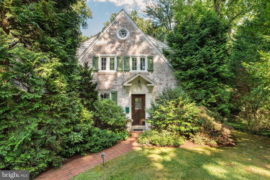 Delight in the charm of the French country cottage presented in this 4 BR, 3.5 BA Penn Valley home on a corner lot within walking distance of the borough of Narberth. Stroll up the brick walkway to the front door with leaded glass, and enter the foyer with an arched nook to the tiled powder room and generous coat closet. From the entryway you can continue down a hallway to the kitchen, but you are immediately drawn to the unique lines of the built-in bookshelf niche and decorative fireplace of the living room, which basks in the light of the room’s multiple windows. Light also emanates from the walls of windows in the serene, tiled-floor sun room off the living room at the back of the home, which steps out onto a lovely composite deck surrounded by lush plantings. Alternatively, a single glass door takes you from the sun room directly to the back yard. Through a living room archway, enter the dining room which features matching glass-front corner cabinets that frame the double windows. Continue to the eat-in kitchen offering wood cabinets, stainless steel appliances--including a Subzero refrigerator, Bosch dishwasher and JennAir  gas cooking--a fun, black-and-white tile backsplash, and a peninsula topped by granite counters. Light and bright, the kitchen includes a breakfast area dotted with skylights and casement windows, which also accesses a charming covered brick patio through sliding glass doors. From the kitchen, continue along a painted brick wall to the laundry room and mudroom area that exits directly to the side driveway. Off the kitchen is the basement access, as well as a sweet butler’s pantry surrounded by exposed brick that leads to a comfortable, good-sized, carpeted family room with bay window. Up the stairs is the primary bedroom with a vaulted ceiling, built-in storage, a generous walk-in closet encased within a dressing nook, and an en suite bath with marble-topped vanity and heated marble floor. Bedroom 2 also provides an en suite bath , while 2 other comfortable bedrooms with interesting curves and nooks share a hall, tiled bath. Gorgeous hardwood floors run through the home, and an 11K generator keeps the lights on in stormy weather. Mature trees and plantings surround the property and create such a quiet, secluded atmosphere, it’s hard to believe the property offers such easy access to Narberth, Suburban Square, award-winning Lower Merion schools and other Main Line treasures, as well as a short, quick ride into the city of Philadelphia.