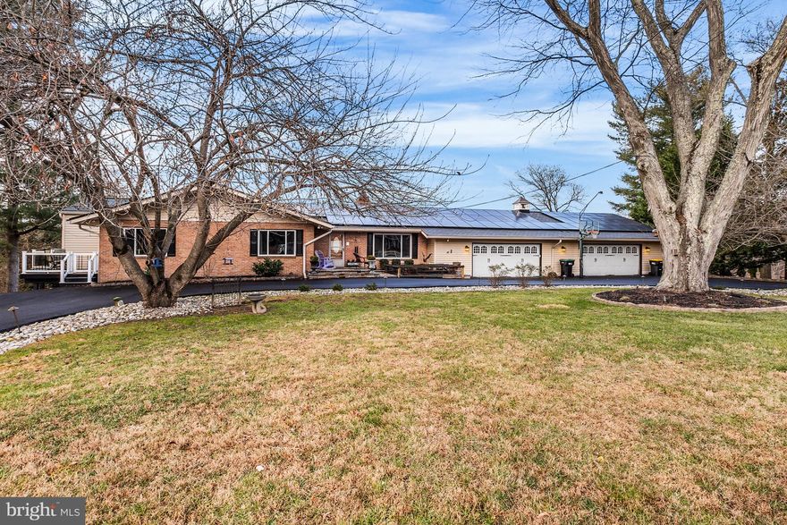 An absolute entertainers dream! This exceptional hillside ranch estate sits on 2.01 acres, one of just four estate-sized lots, and offers a rare blend of master craftsmanship, advanced systems, and true resort-style living. From the moment you arrive, the home makes a lasting impression with a recently refinished paved circular driveway and a serene front Koi pond, creating a sense of privacy and tranquility before you even step inside. The exterior is anchored by a $90,000 state-of-the-art composite roof designed to emulate natural slate, engineered for long-term performance and durability. Thoughtfully upgraded for modern living, the home includes a whole-house Generac generator (2 years old), a new HVAC system (6 months old), updated plumbing converted from copper to PVC, oversized gutters with leaf protection, replacement windows, and new interior and exterior doors—delivering efficiency, reliability, and peace of mind. Inside, luxury vinyl plank flooring flows throughout the home, complemented by ship-lap ceilings on the main level and a beautifully renovated kitchen that balances timeless design with everyday functionality. The residence offers three full bathrooms, including a spacious primary suite featuring a Jacuzzi tub, along with exceptional storage and a walkable attic. Outdoor living is where this property truly shines. Approximately 2,000 square feet of composite decking with integrated tube lighting sets the stage for year-round enjoyment. Highlights include a separate golf deck with an opening rail and spiral staircase, as well as a double-joisted deck section pre-engineered for a future hot tub. More than $150,000 in professional hardscaping surrounds the saltwater, heated in-ground pool with automatic cover, transforming the backyard into a private oasis. Additional features include a pool house with electric, a stage with built-in lighting, and multiple thoughtfully designed spaces for entertaining and relaxation. The entire perimeter of the parcel is also outfitted with an invisible fence. Completing the estate are a five-car garage with extensive industrial shelving, a comprehensive security system with exterior and interior cameras plus window and door alarms, a whole-house water treatment system (3 years old), and a modern, multi-zone septic system. Meticulously maintained and exceptionally well engineered, this one-of-a-kind property offers comfort, security, and elevated indoor-outdoor living, an extraordinary opportunity rarely found.