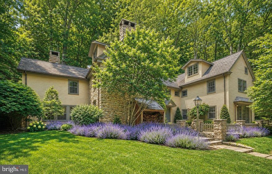 With roots dating back to the 1700s, "The Beacham House" is a magical haven banked into seven hillside acres on sought after Honey Hollow Road within Bucks County, PA. This special estate exudes storybook allure, with preserved architectural materials, dramatic stone walls, rich hardwoods, and hand-hewn exposed beams that bring warmth and character throughout. The property consists of a circa 1820 stone house, a detached carriage house with full gym, a newly installed gunite lap pool, extensive hardscaping, mature landscaping and a hot tub built into stone boulders. The meticulous preservation of this estate reflects an unwavering commitment to maintain the integrity of the property, a dedication that has borne fruit in the form of a breathtaking sanctuary. The designer of this estate has ensured that every nuance within this oasis embodies the highest quality materials, and anything that was reconfigured was done so using natural components from the surrounding environment. Within the main residence, a charming kitchen boasts custom-made cabinetry, soapstone countertops, an integrated butcher block, and top-tier appliances featuring a SubZero refrigerator and a six-burner Wolf range with vented hood, all atop radiant heated flooring. A welcoming breakfast nook, opening onto an elegant stone patio via French doors, overlooks the lavender gardens, thus extending the interior living space into the natural surroundings. Italian tile detailing and wide-plank hardwood floors enhance both homes, while Pella architectural windows allow abundant natural light to flood the interiors. A stone adorned wood-burning stove is the focal point of the living room and emanates quintessential Bucks County charm. Just beyond is an inviting sitting area—ideal for leisurely reading, relaxation, or an office space. Ascend the staircase, skillfully repurposed by hand using reclaimed wood from the estate, to discover the Owner's Suite. This suite showcases exposed beams, a fireplace, a full bathroom with a glass shower, soaking tub, and a hidden staircase—adding to the home’s unique character. Two additional bedrooms with ample closet spaces, a full hallway bathroom, and a spacious fully finished attic on the third floor complete the upstairs accommodation. The darling carriage house, having undergone a complete renovation, features a deluxe kitchen with soapstone countertops, bar seating, a refrigerator, oven, and a Bosch dishwasher. Exposed stone embellishes the walls of the living room, and French doors open up to a private patio offering serene poolside and property views. The upper level includes a bedroom, a full bathroom, walk-in closet, and direct access to a private gym. The exterior of the property is equally captivating with its heated lap pool w/automatic retractable cover, a four-person hot tub, a new shed, chicken coop, and newly installed split rail fencing, encompassing a picturesque landscape that includes secluded woodland and grassy areas. The carriage house also showcases a two-car garage with handcrafted Spanish Cedar doors featuring specially crafted hardware cognizant of the time period. The exceptional characteristics of this estate are highlighted by a half-century lifespan cedar roof on the primary residence, new metal roofing and copper drain systems on both homes, a centralized vacuum system, water purification and softening installations, and a recently installed septic system. Occupying an idyllic location equidistant to the heart of Bucks Counties best small towns, and nearby all major commuter routes, the sanctuary known as "The Beacham House" presents a remarkable fusion of preserved craftsmanship, endearing allure, and everlasting enchantment. *All contents within the property are also available. Main house is 3 bed/2.5 bath. Guest Cottage is 1 bed/1 bath.