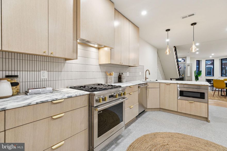 Welcome to 2223 Saint Albans Street, a stunningly renovated 3-story home nestled on one of the most picturesque tree-lined blocks in Graduate Hospital. This property boasts an approved 10-Year Tax Abatement and an exquisite blend of historic charm and modern luxury. The restored original brownstone facade and a beautifully refinished Philadelphia "Hollywood door" set the tone, leading into a marble hexagon-tiled vestibule with restored double doors. Every detail of this home has been thoughtfully designed, featuring white oak herringbone floors, solid core five-panel doors with satin brass hardware, and a curved iron railing along the open-ended oak staircase framed by an exposed brick wall. The first floor offers ample space for a large living area and dining table, with the herringbone floors transitioning seamlessly into terrazzo tiles in the custom-designed kitchen. Here, you'll find lime-washed white oak cabinetry, GE Monogram appliances, brass fixtures, honed Arabescato marble countertops, and a finger-tile backsplash—a true chef’s dream. A convenient powder room and a herringbone-paved rear yard complete the first floor. The second floor includes a rear ensuite bedroom with a curb-less European-style shower adorned with red clay tiles and matte black fixtures, a hall bathroom with a Kohler tub and stainless steel accents, and a bright front-facing bedroom with generous closet space. A laundry room adds functionality to this level. The third floor is dedicated to the Primary Suite, offering a spacious bedroom with room for a sitting area and desk, a custom walk-in closet, and a luxurious bath with a fluted white oak double vanity and a wet room featuring a soaking tub and a three-piece shower. Above it all is a Trex roof deck with TPO roofing, providing incredible city views. A fully finished basement offers additional living and storage space. Modern conveniences include dual-zone HVAC, recessed LED lighting, and a tankless water heater for energy efficiency. Situated just steps from Rittenhouse and Fitler Square Parks, as well as top neighborhood favorites like Ultimo, Rival Bros, Sally, Loco Pez, Pub & Kitchen, Café Lutecia, City Fitness, and Friday Saturday Sunday, this home is also a short walk to UPenn, CHOP, and major roadways via the South Street Bridge. 2223 Saint Albans Street is the perfect blend of timeless elegance and contemporary living—don’t miss your chance to call it home!