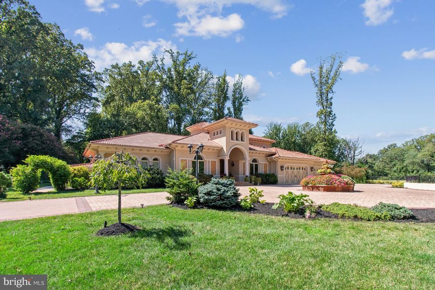 Welcome to an enhanced Mediterranean sanctuary, now available at a new attractive price and boasting a rejuvenated aesthetic that highlights its enduring elegance. Nestled on an expansive 2.4-acre estate, this property masterfully blends Italian architectural grace with the vibrant essence of Mediterranean gardens and a secluded pool retreat, offering a serene escape mere moments from the heart of downtown McLean. The residence greets you with its distinctive red tile roof sourced from Italy, complemented by stucco exteriors and intricate stone details, embodying the quintessential Mediterranean charm. Upon entering, you are welcomed by exquisite carved doors featuring wrought iron embellishments, leading you into an interior of unparalleled sophistication. The grand foyer, adorned with bespoke Versace tiles, ushers you into elegantly appointed living spaces, including a formal dining room, a serene living room, and a distinguished home office framed by French doors. The state-of-the-art designer kitchen serves as the heart of the home, equipped with premium appliances, custom cabinetry, and an auxiliary catering kitchen to streamline culinary endeavors. An adjacent balcony with a grill connection enhances the culinary experience. The main level continues to impress with a cozy breakfast nook opening to a majestic family room with a stone fireplace, a media room, and a sun-drenched conservatory offering sweeping views of the verdant grounds. The owner's suite on the main level is a private haven, featuring direct access to the pool and dual walk-in closets, complemented by a luxurious bath with dual vanities, a whirlpool tub, and a steam shower, epitomizing spa-like indulgence. Upstairs, four spacious ensuite bedrooms await, while the lower level reveals a sanctuary of entertainment and relaxation, including a recreation room, fitness area, sauna, game room, and additional bedroom suite. Outside, the exquisitely landscaped gardens and a dedicated vegetable patch envelop you in nature's tranquility, while the pool area, complete with a waterfall and outdoor kitchen, offers a sublime retreat. This Mediterranean jewel embodies a lifestyle of sophistication and leisure, promising a unique blend of cultural richness and contemporary comfort.